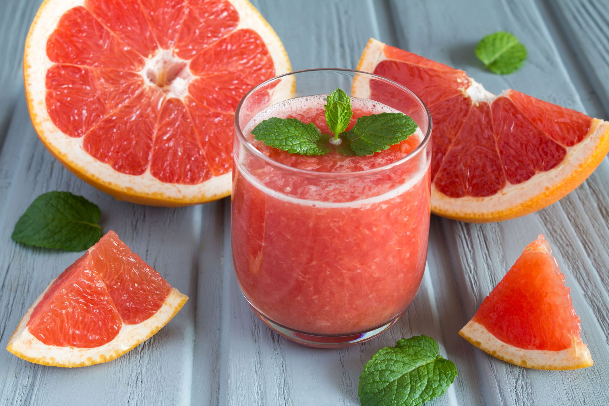 Grapefruit smoothie on the gray wooden background. Close-up.