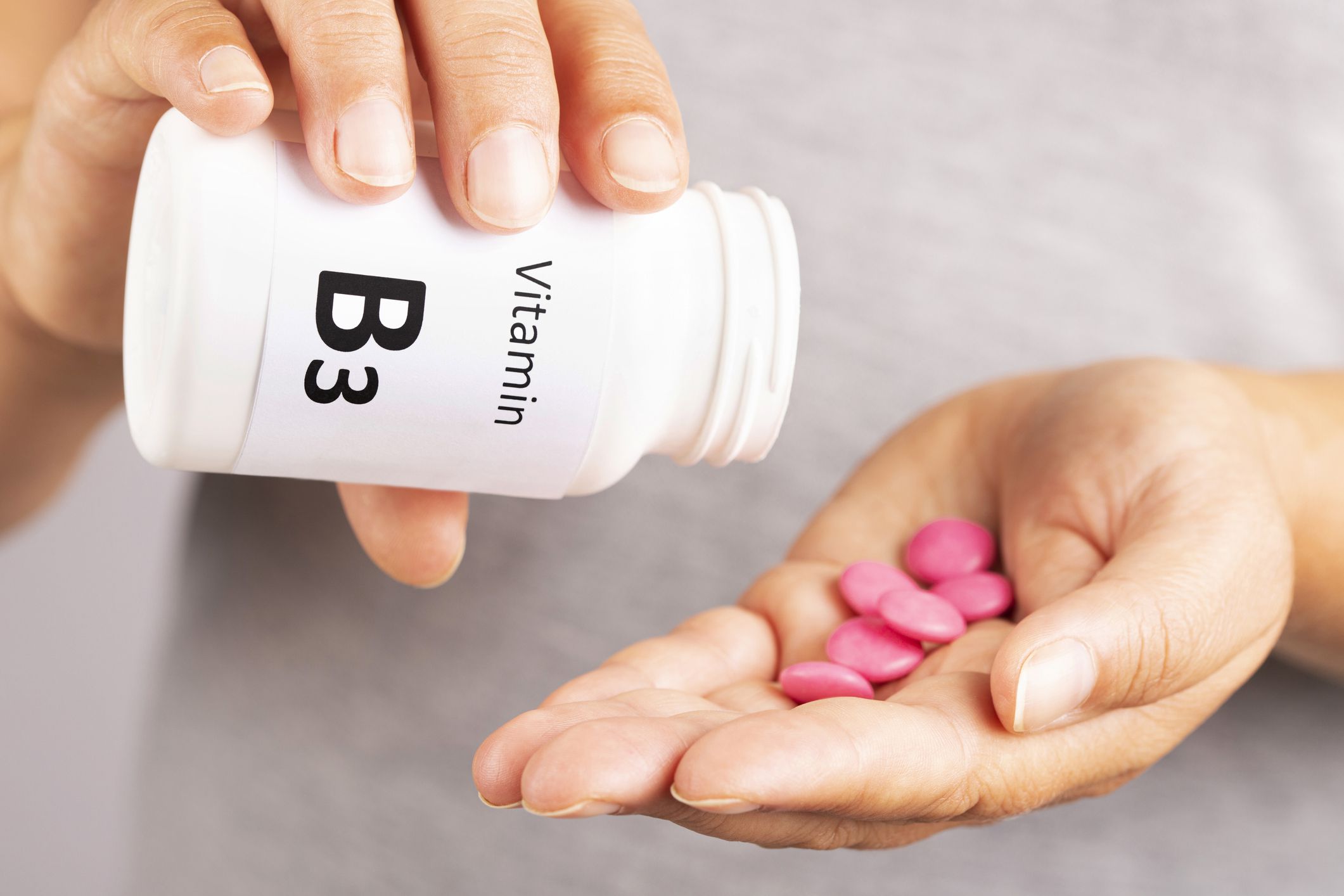 Woman hand takes vitamin B3 from medicine container