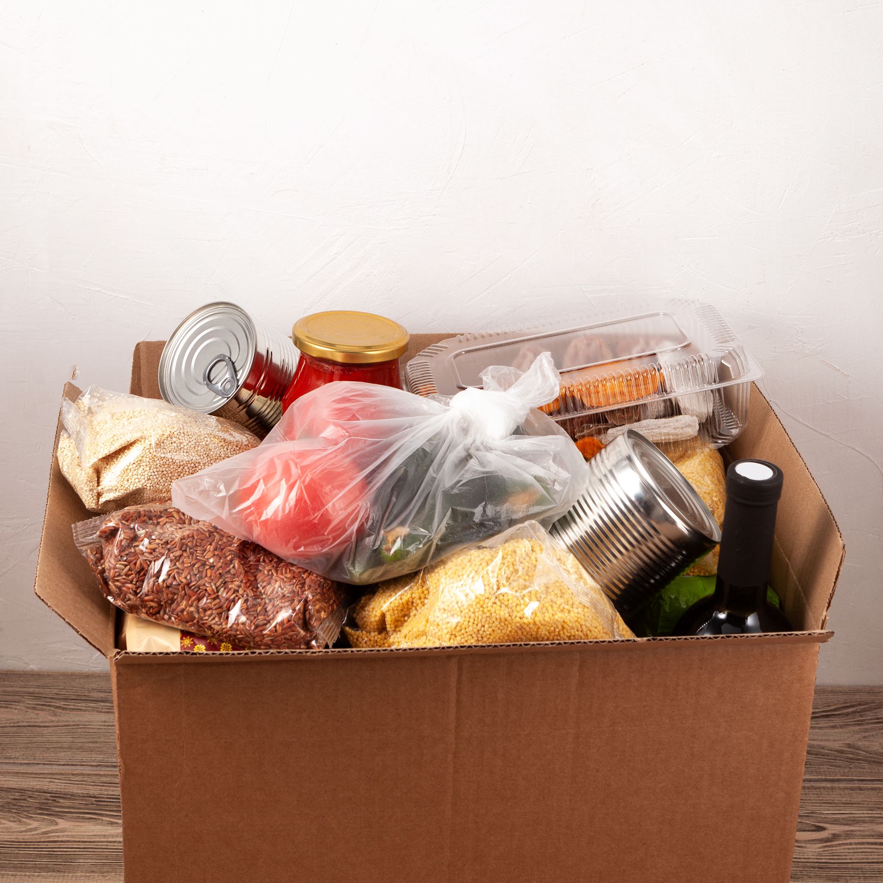 Social food donation. Safe contactless home food delivery. Cardboard box with different food products. Safe express delivery concept. Selective focus, copy space.