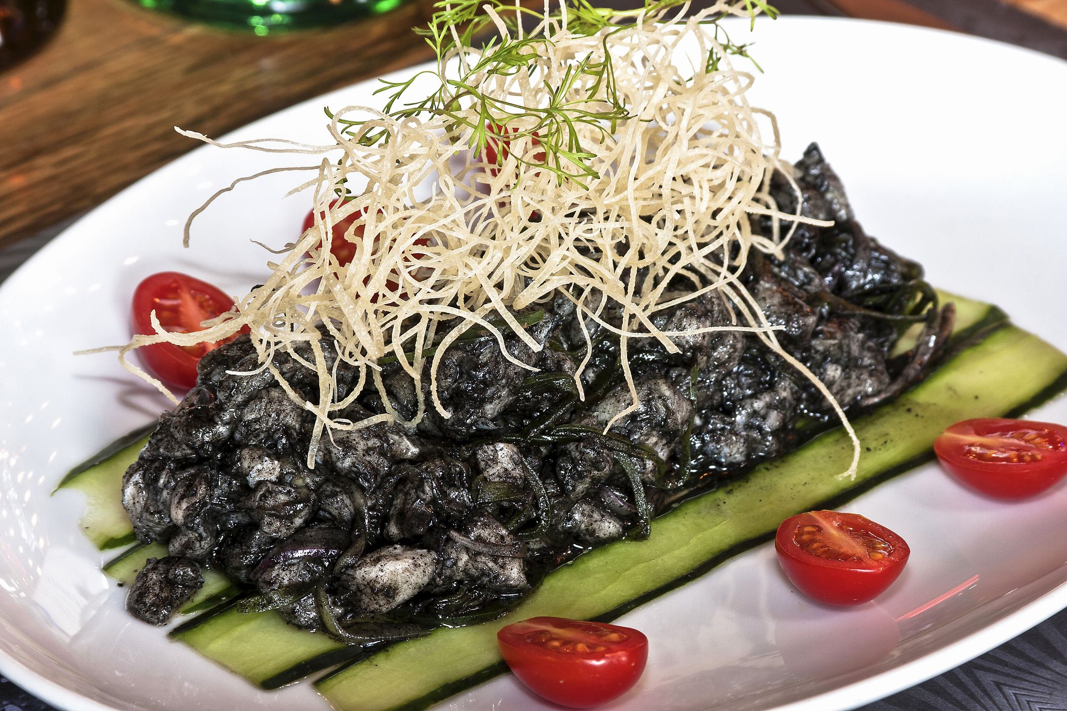Plate of huitlacoche with tomato, cucumber and fries on restaurant table, Mexican food