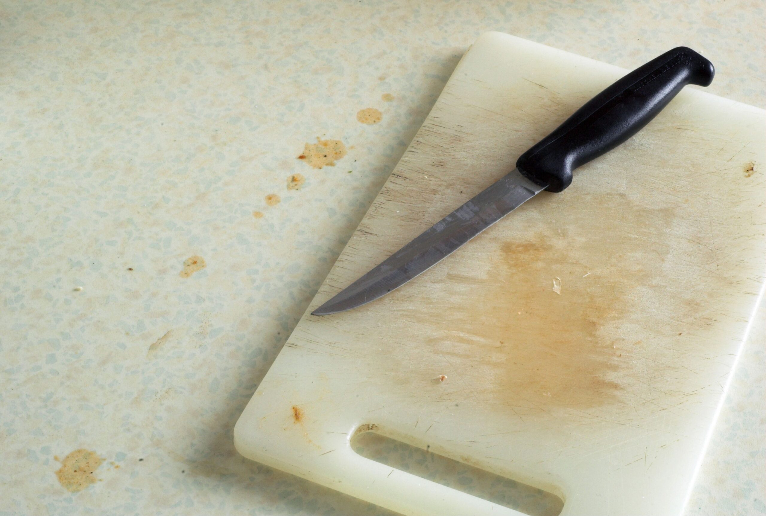 Dirty kitchen food preparation chopping board and knife.