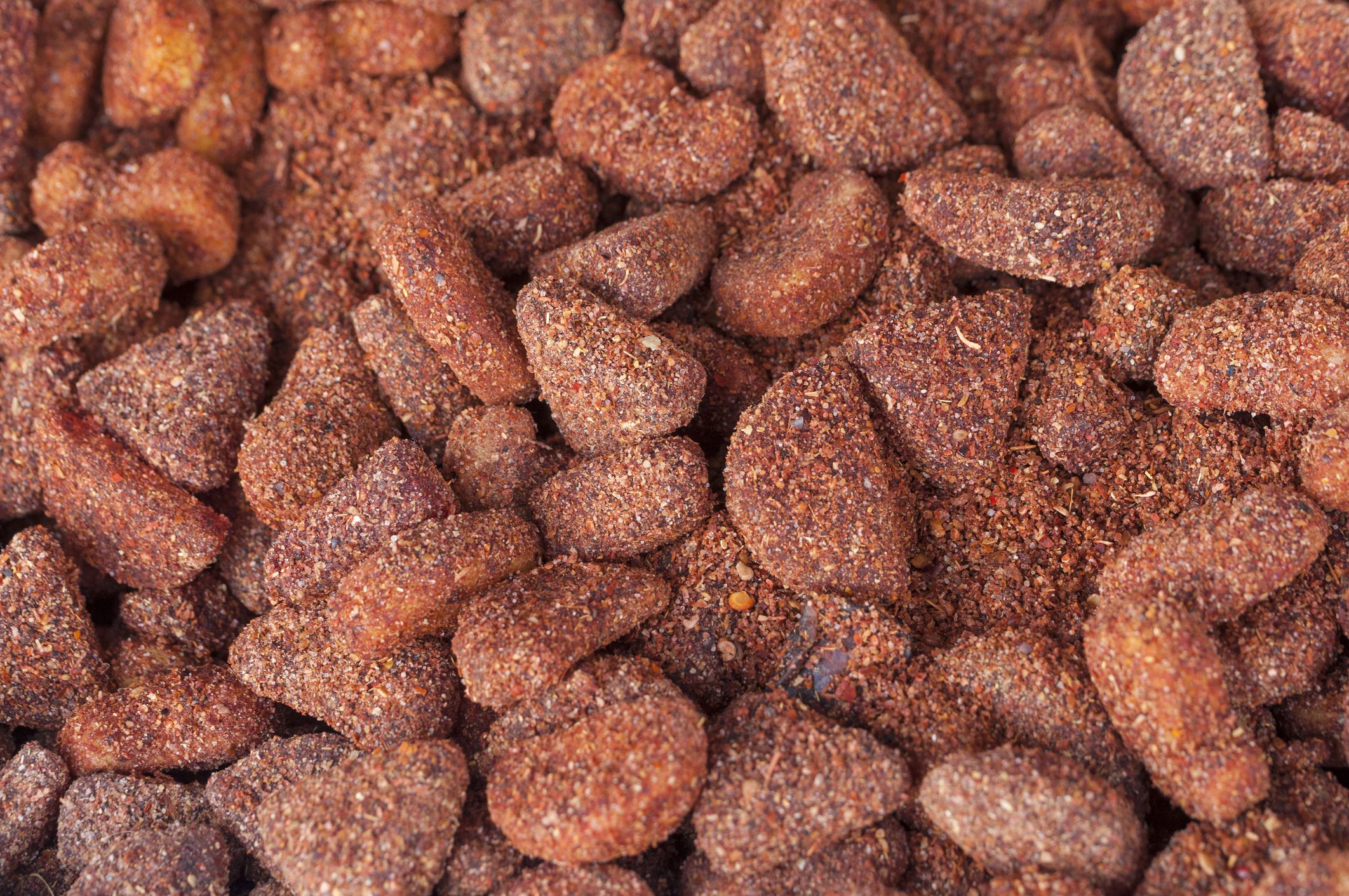 Bin of preserved fruit pieces covered with chili and salt granules in Mexican market
