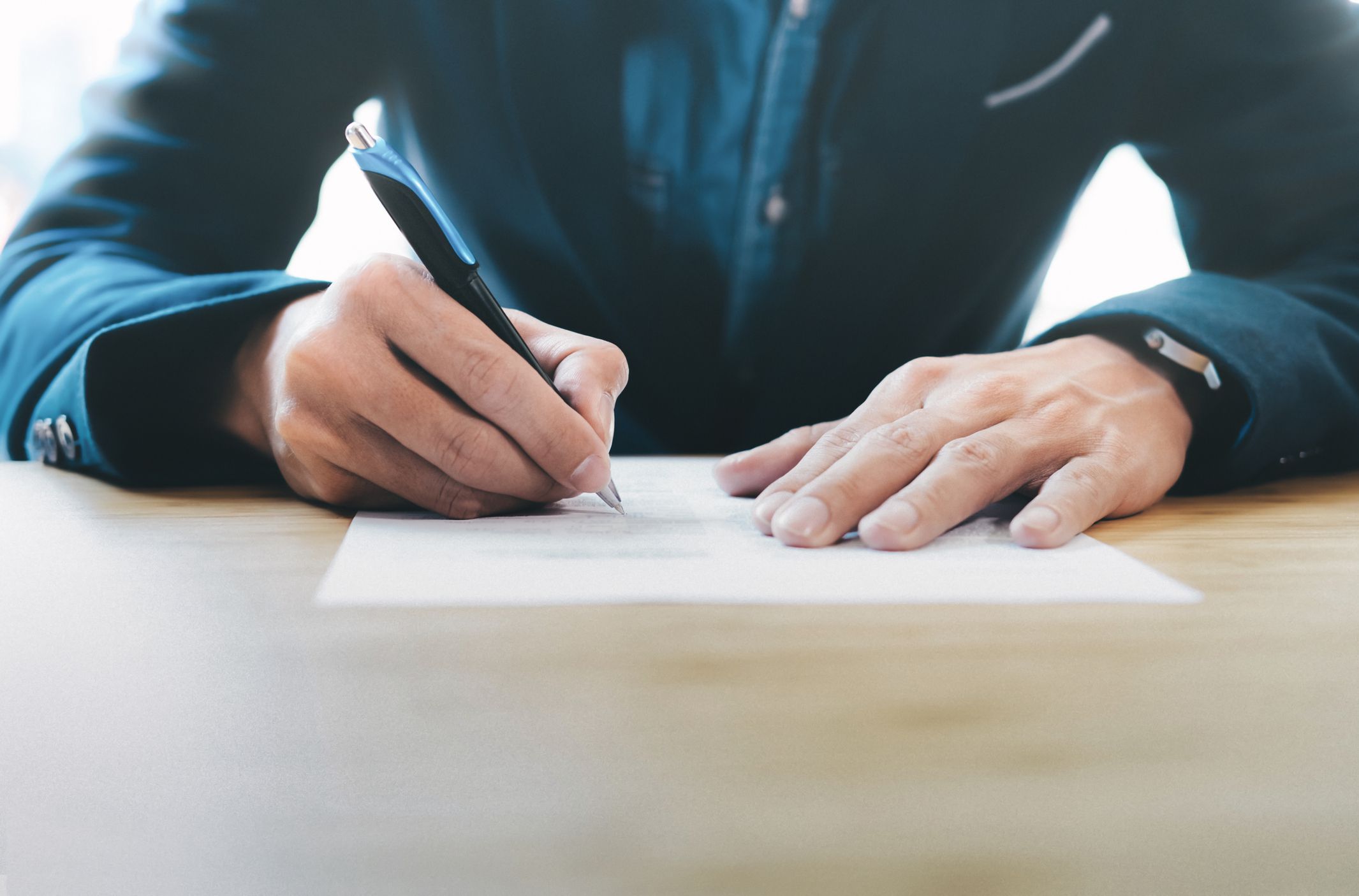 Close up businessman signing contract making a deal.