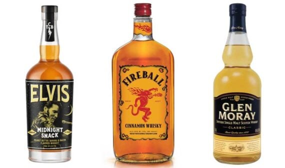 Three bottles, often listed among the worst whiskeys by critics, are shown: Elvis Midnight Snack on the left, Fireball Cinnamon Whisky in the center, and Glen Moray Single Malt Scotch Whisky on the right, all upright against a white background.