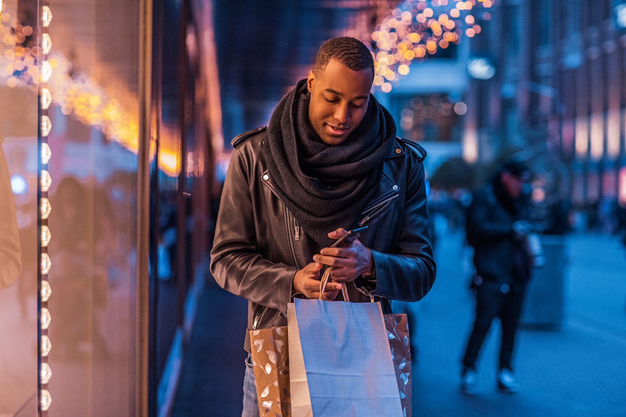 Handsome brunette black male tourist enjoying winter shopping in the high street