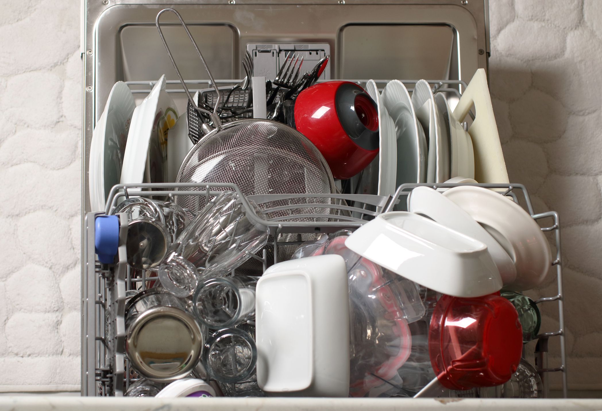 Dishwasher full with clean dishes in kitchen