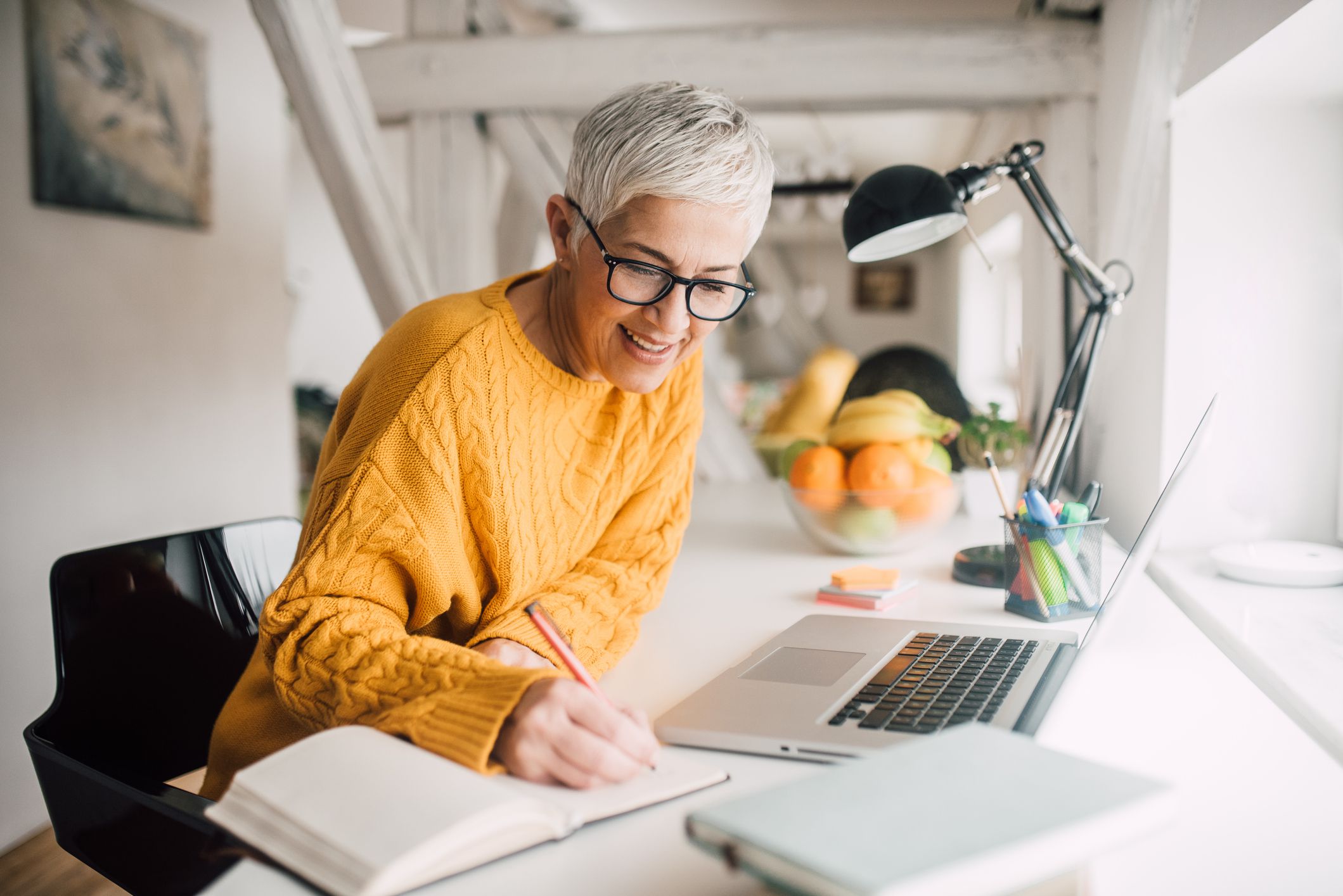 Happy mature woman taking notes