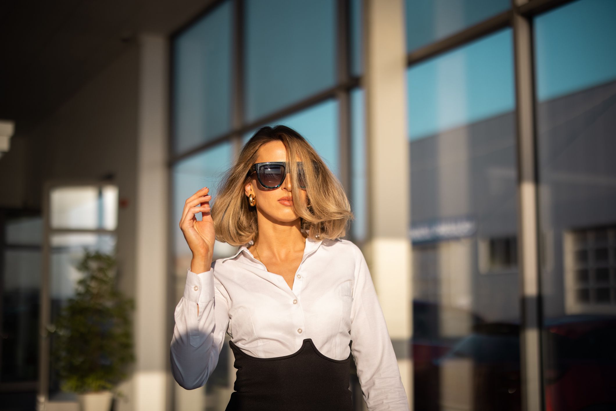 Young well dressed woman with sunglasses leaving car dealership