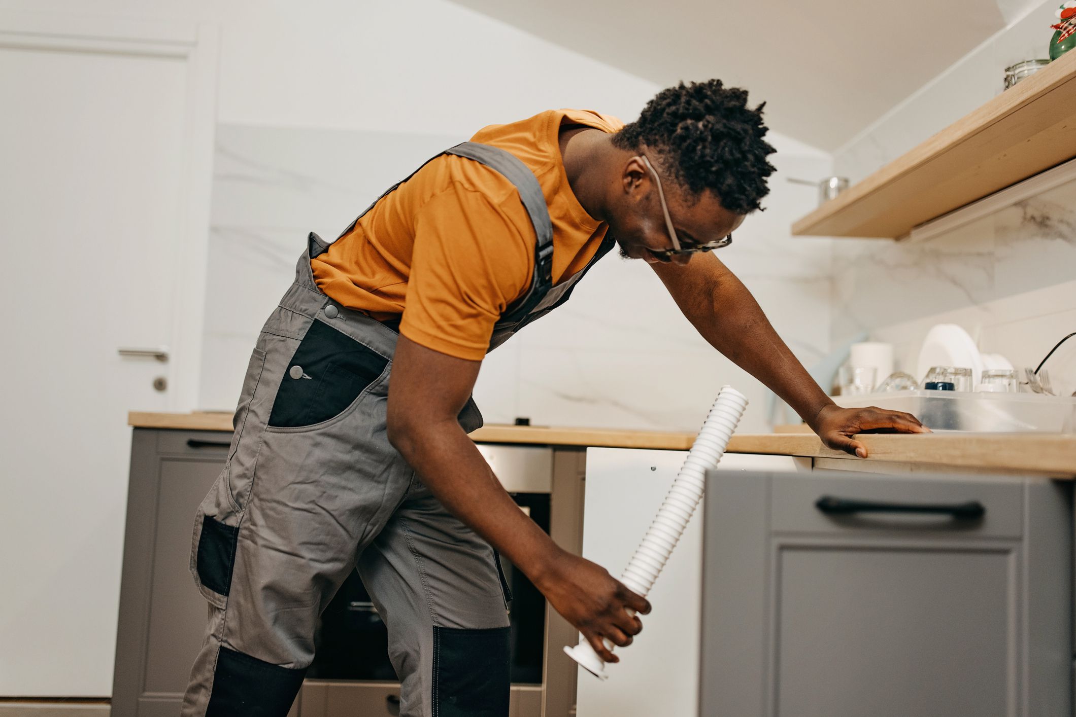 Plumber fixing kitchen sink