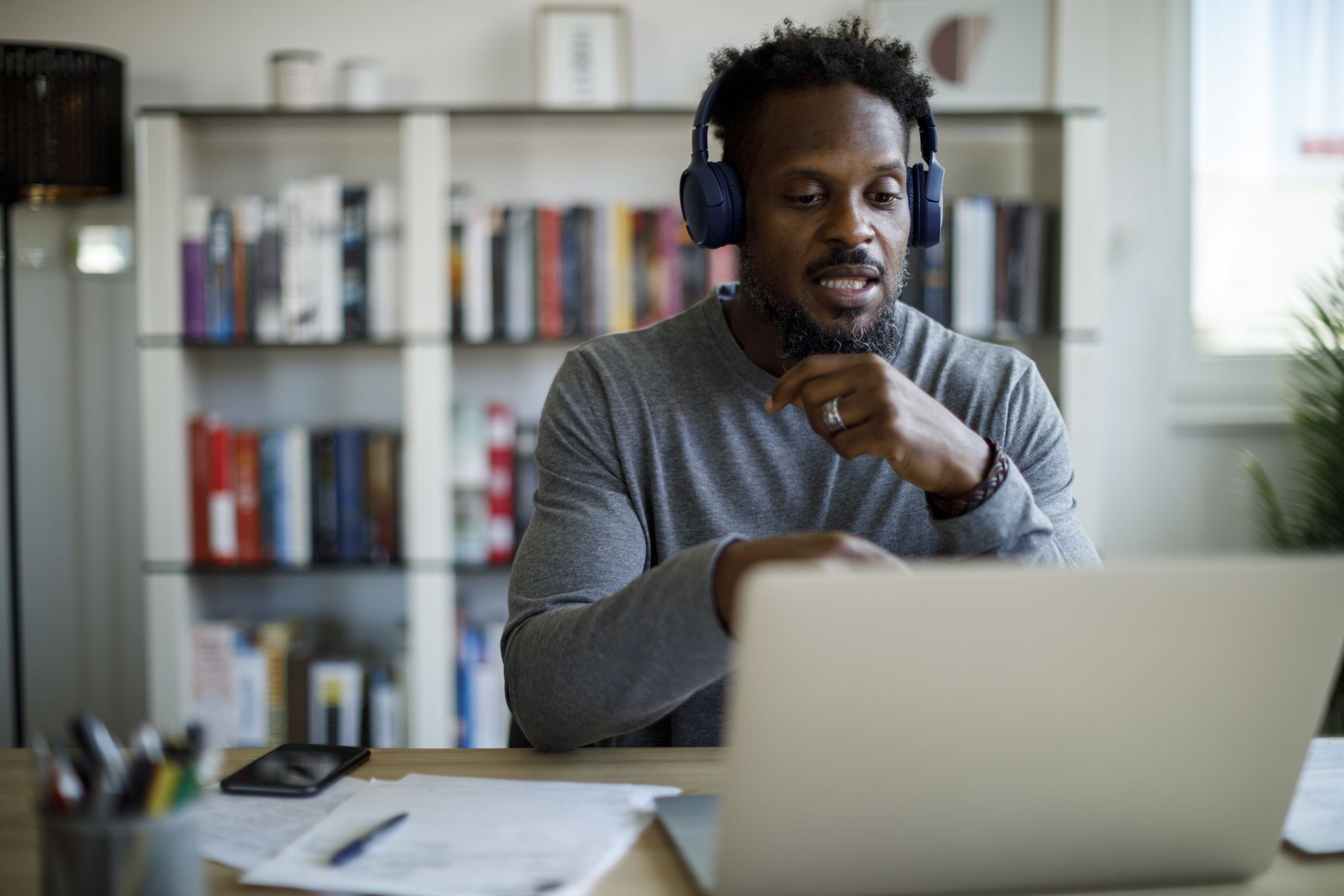 Man with headphones attends an online course at home