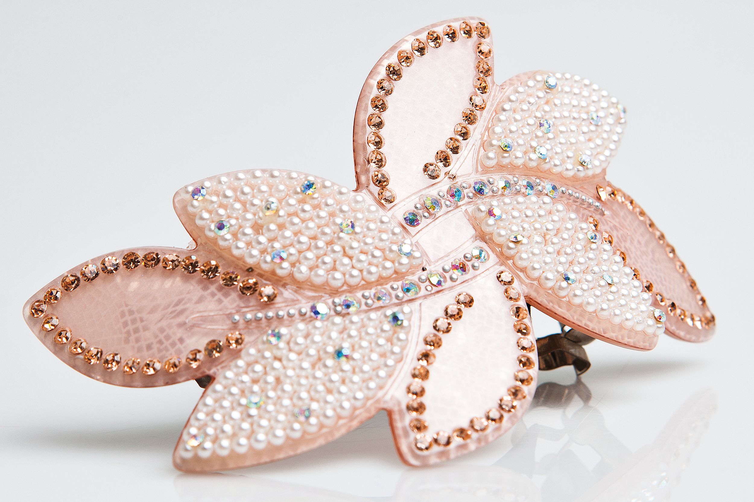 Pink jeweled fashion hair clip with small fake pearls, diamonds, and yellow gems, on a white background