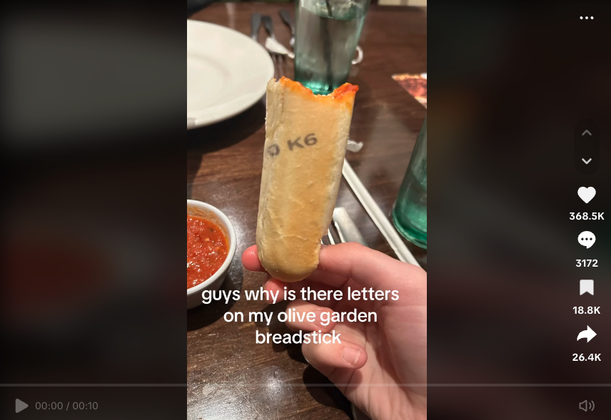 TikTok of half-eaten breadstick at Olive Garden with printing on it