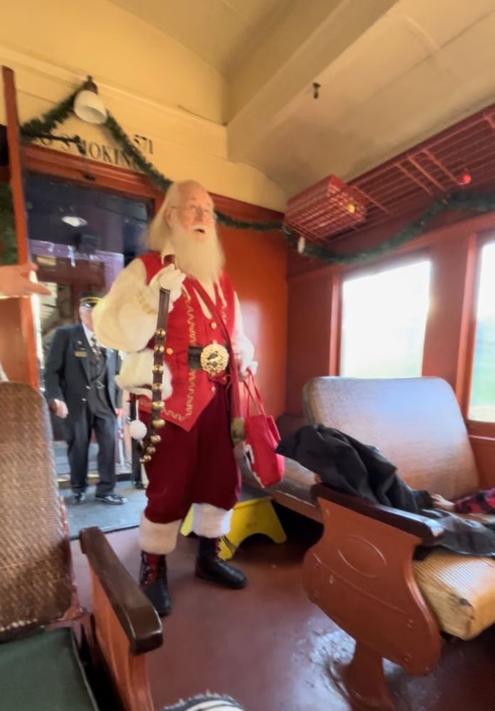A Santa figure inside a steam train cabin
