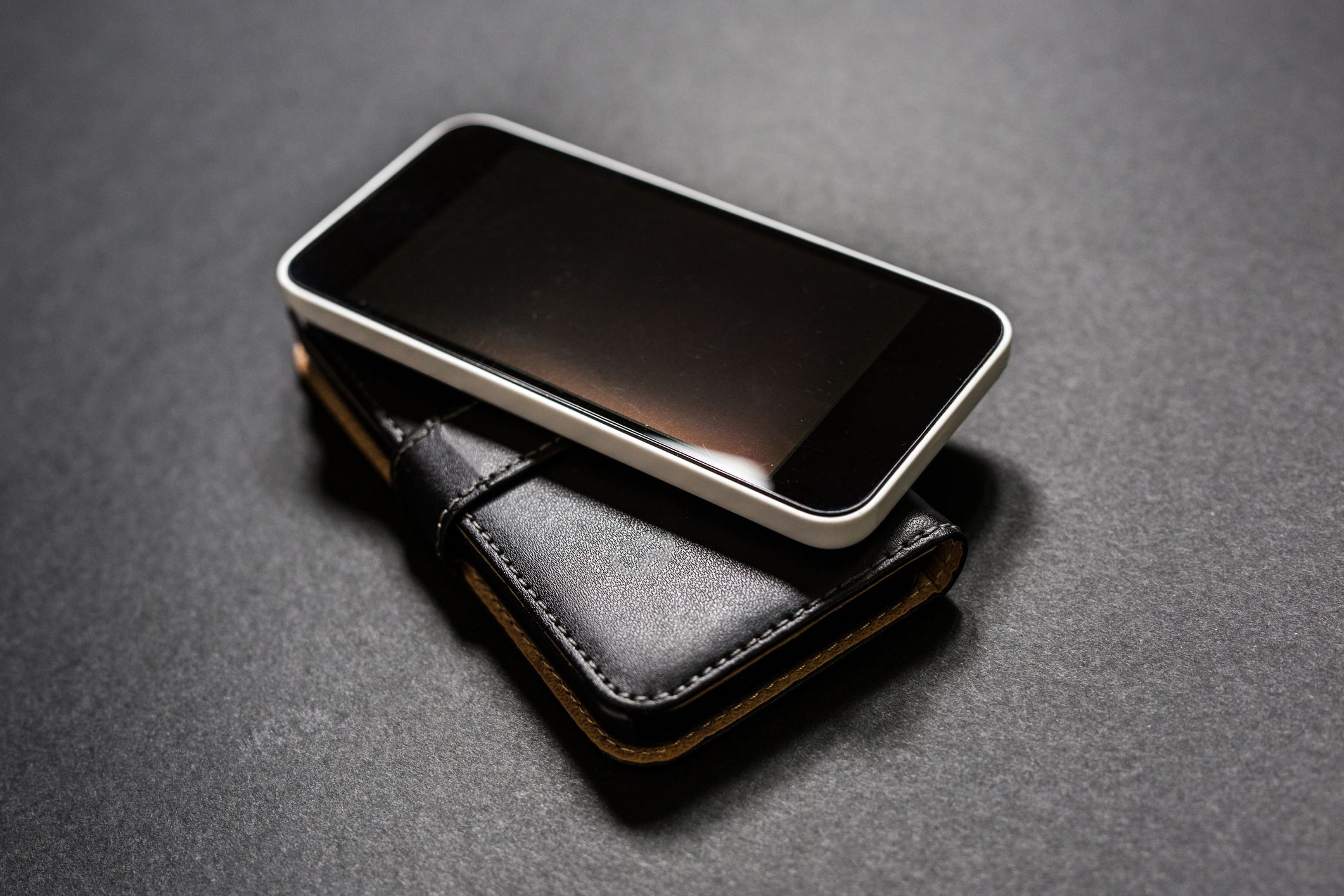 Smartphone and wallet on black background