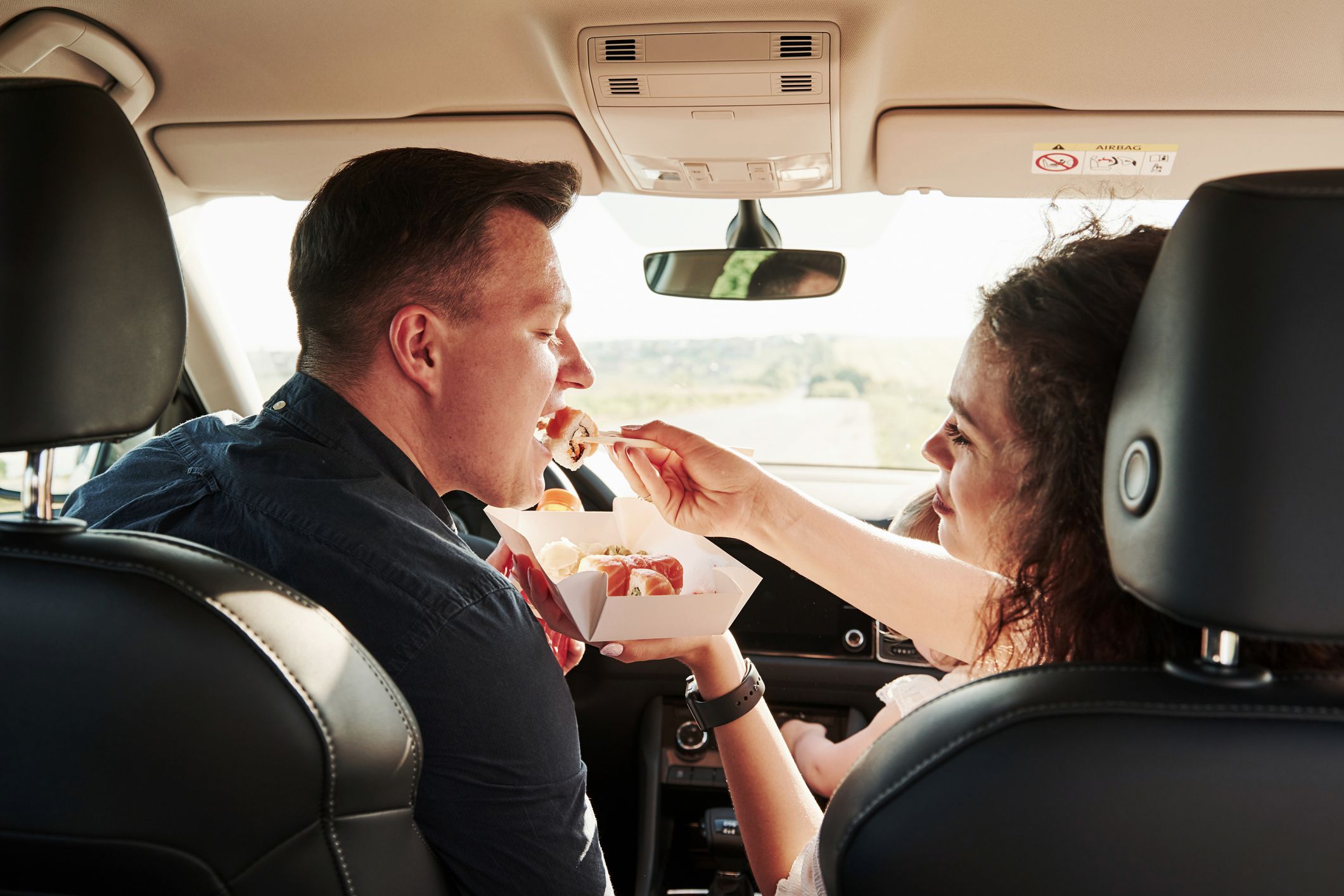 Eats sushi. Beautiful people is in the modern car at their weekends.