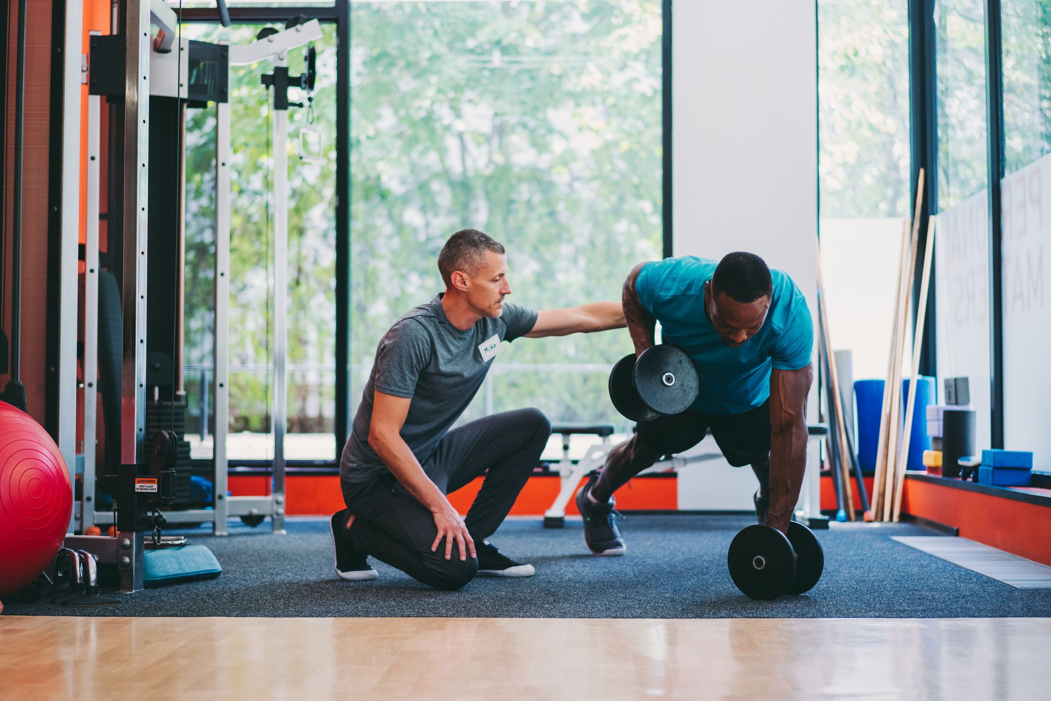 Sportsman in plank position exercising dumbbell push-ups