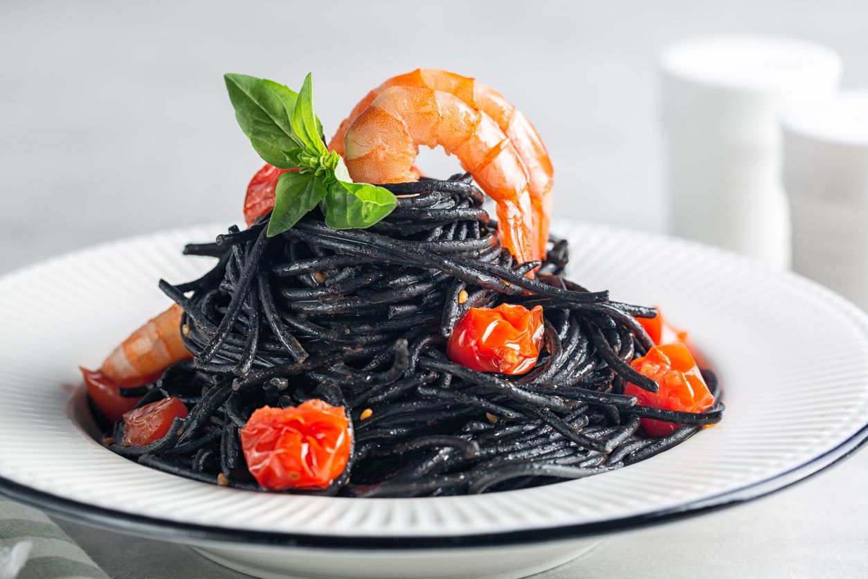 An image of a bowl of black-colored squid ink pasta.