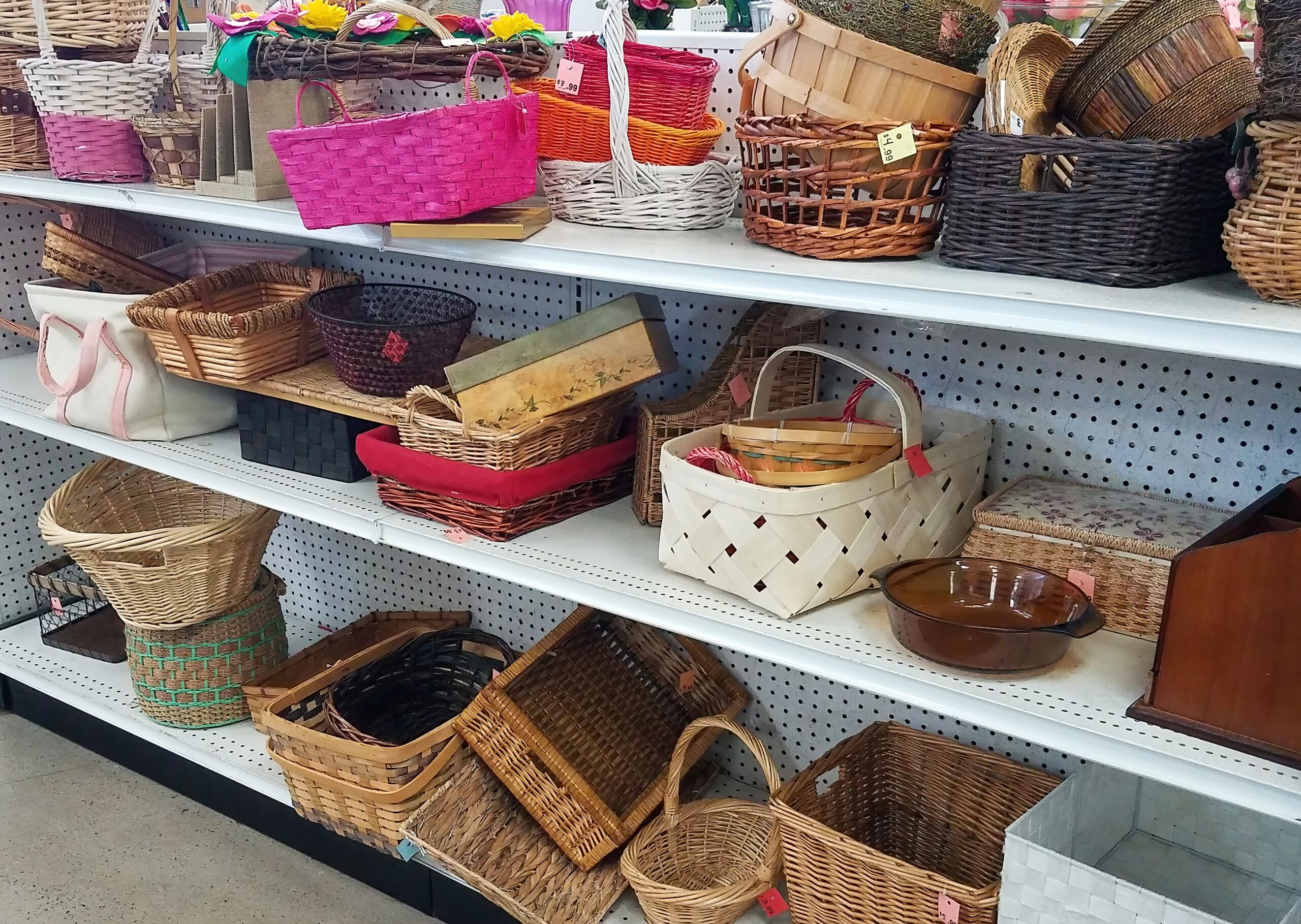 White shelves of used straw baskets in a thrift store.