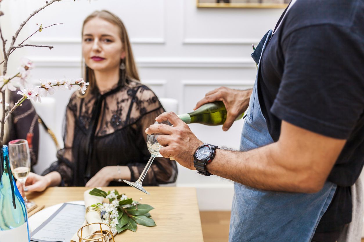 A private chef pouring wine.