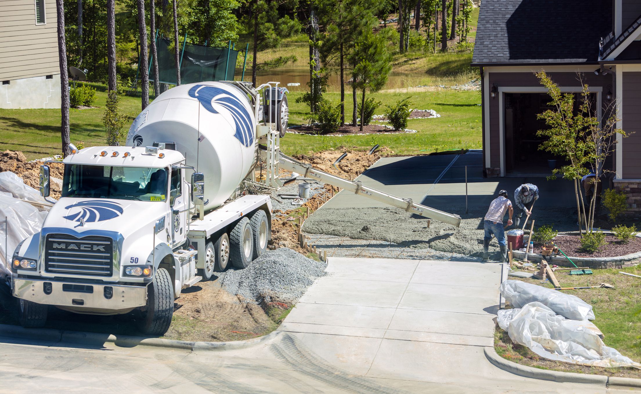 New Hill, North Carolina, USA: 1st June 2020; Unidentifiable Hispanic men working on a new concrete driveway at a residential home