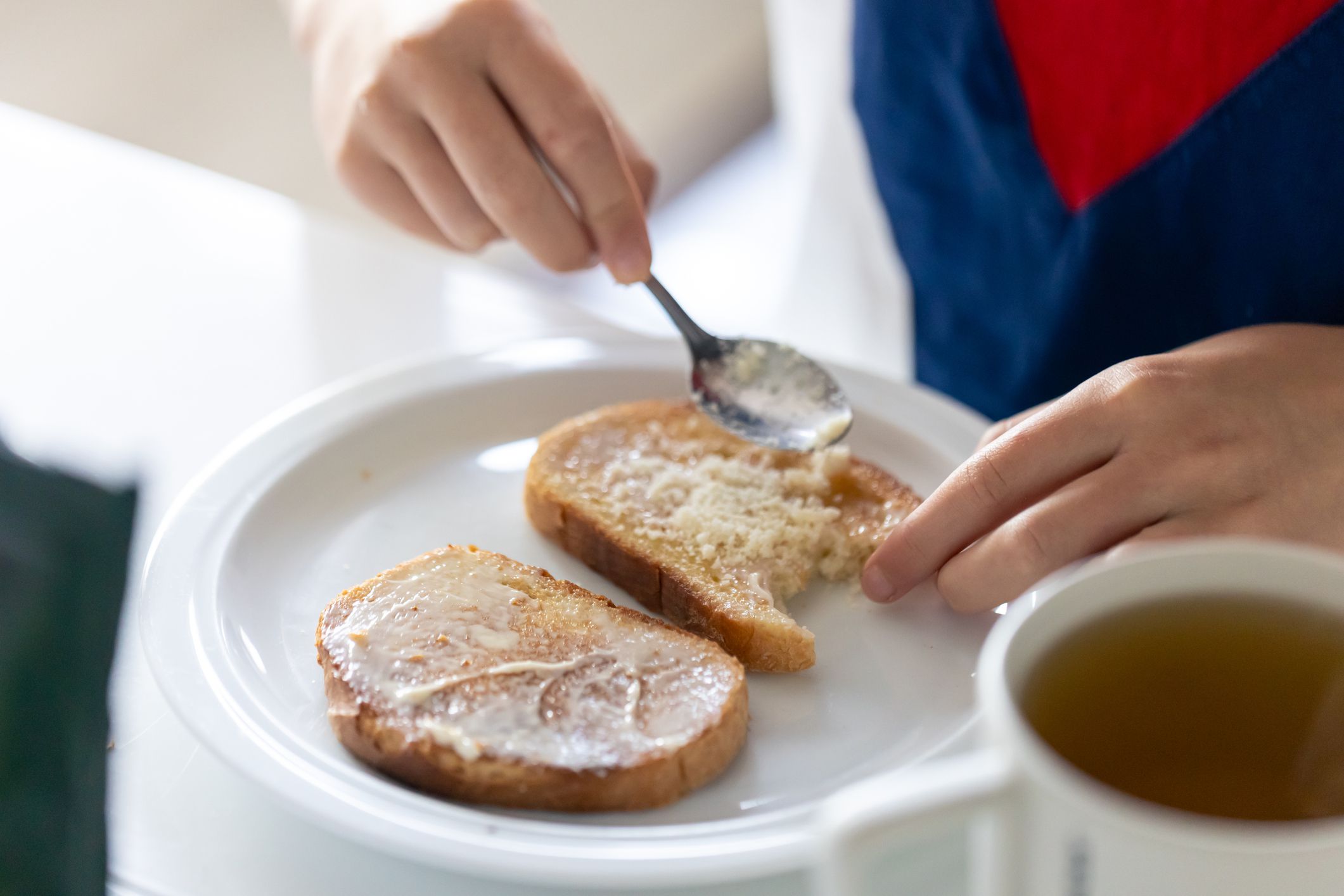 A woman sprinkles a piece of bread with grated cheese, a delicious breakfast.