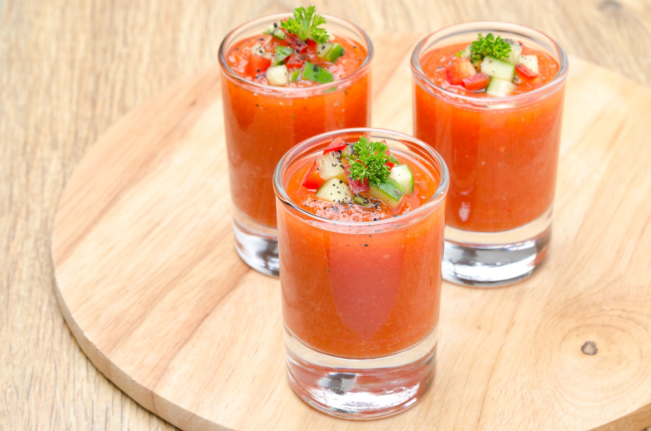 cold tomato soup gazpacho in portion glasses on a wooden board, horizontal