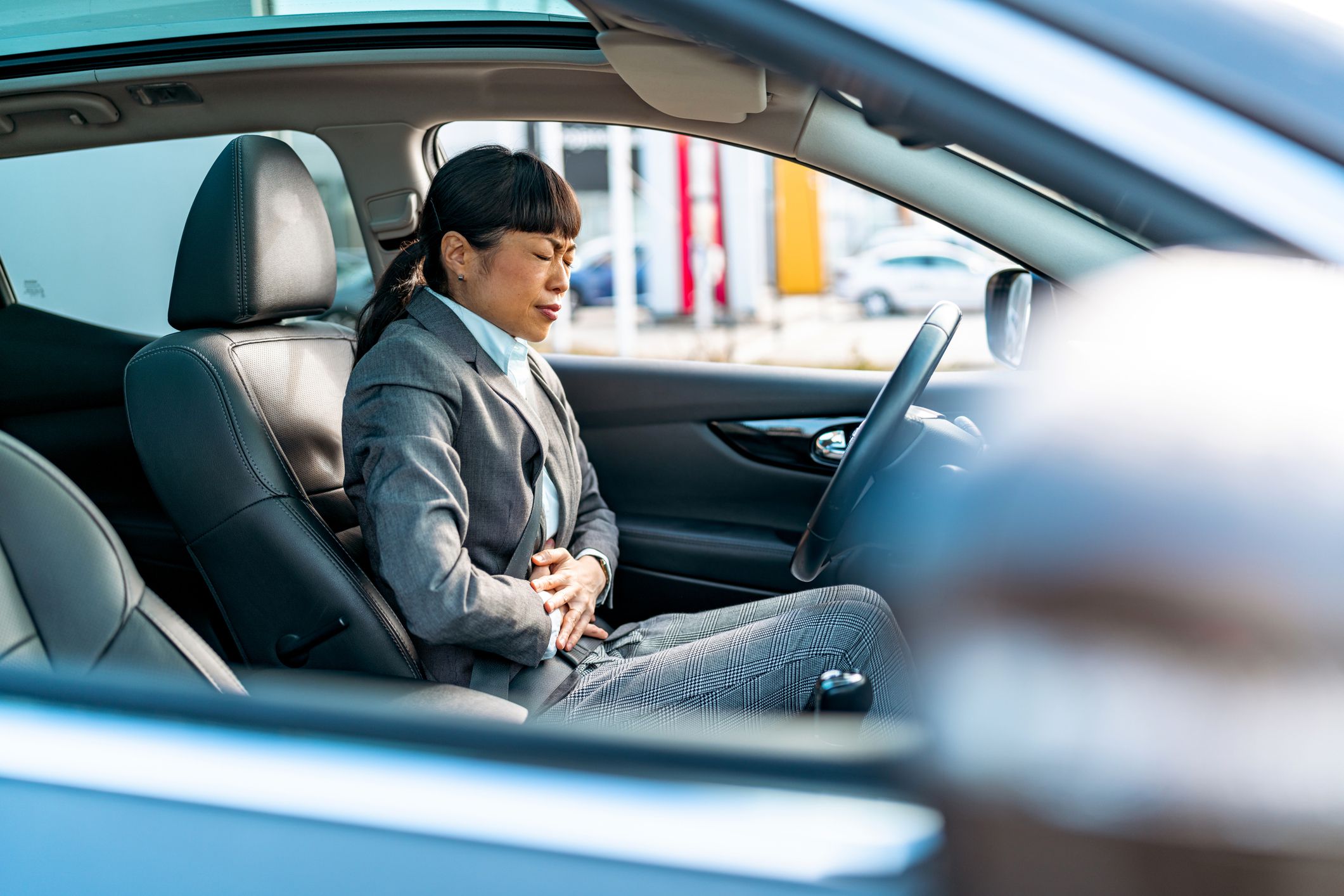As she drives, the mature Chinese businesswoman grapples with stomach pain, a stark reminder of the unseen challenges faced on the road to success, where personal health battles remain hidden yet significant
