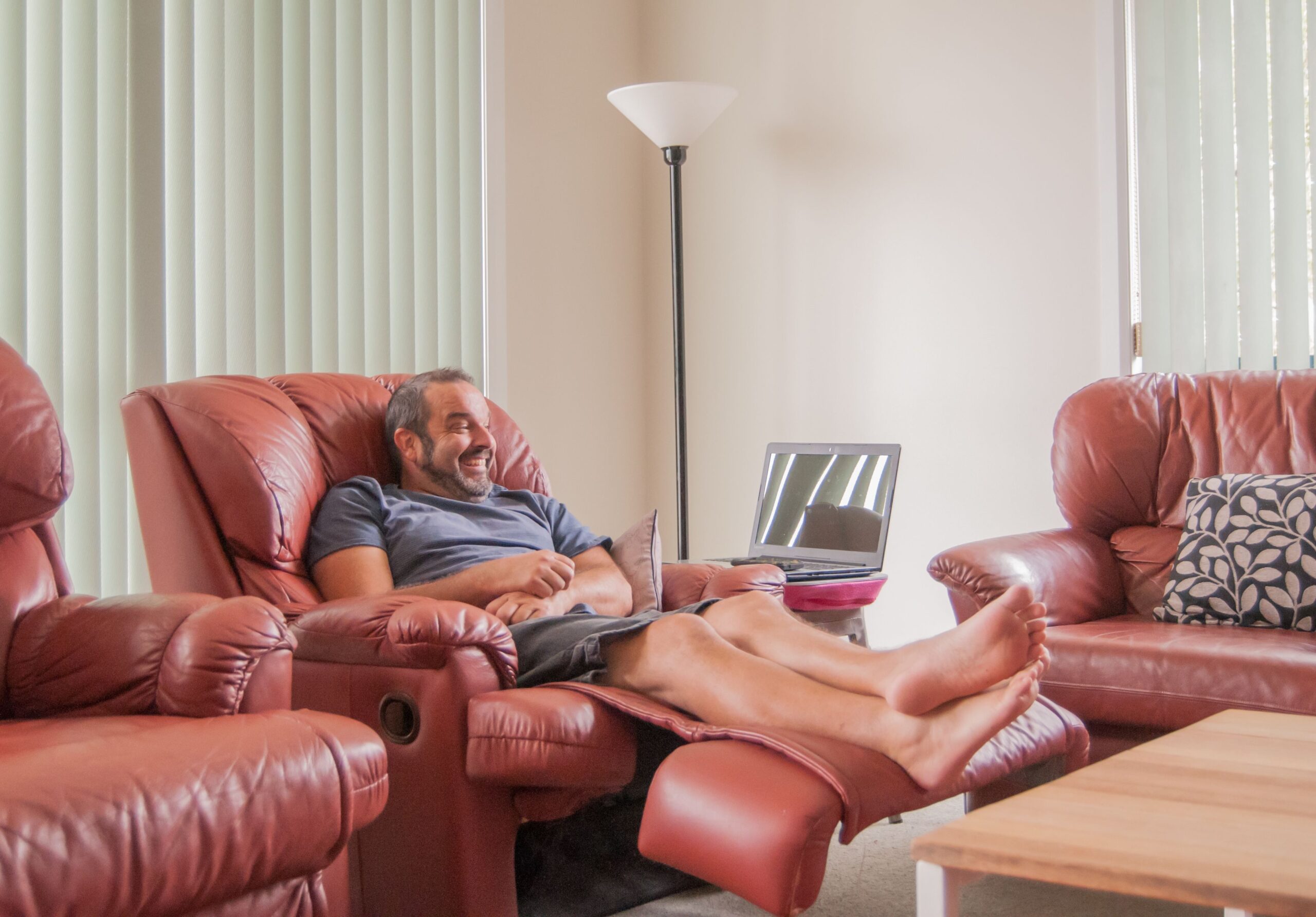 Mature aged man seating in leather recliner in a middle class living room.