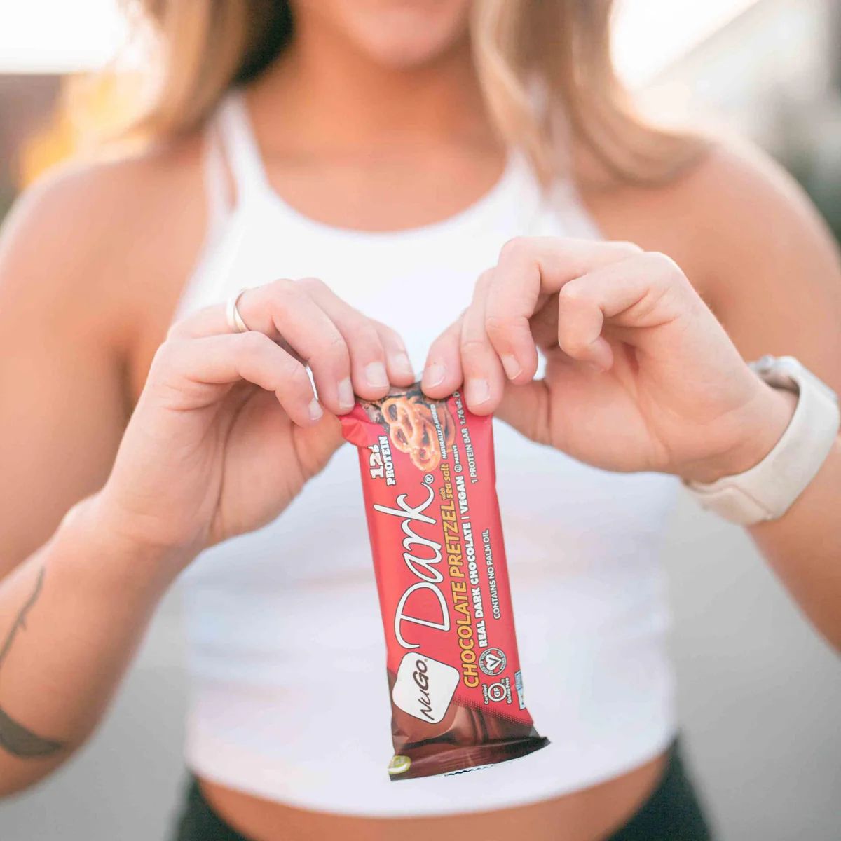 a girl holding NuGo Dark Chocolate Pretzel