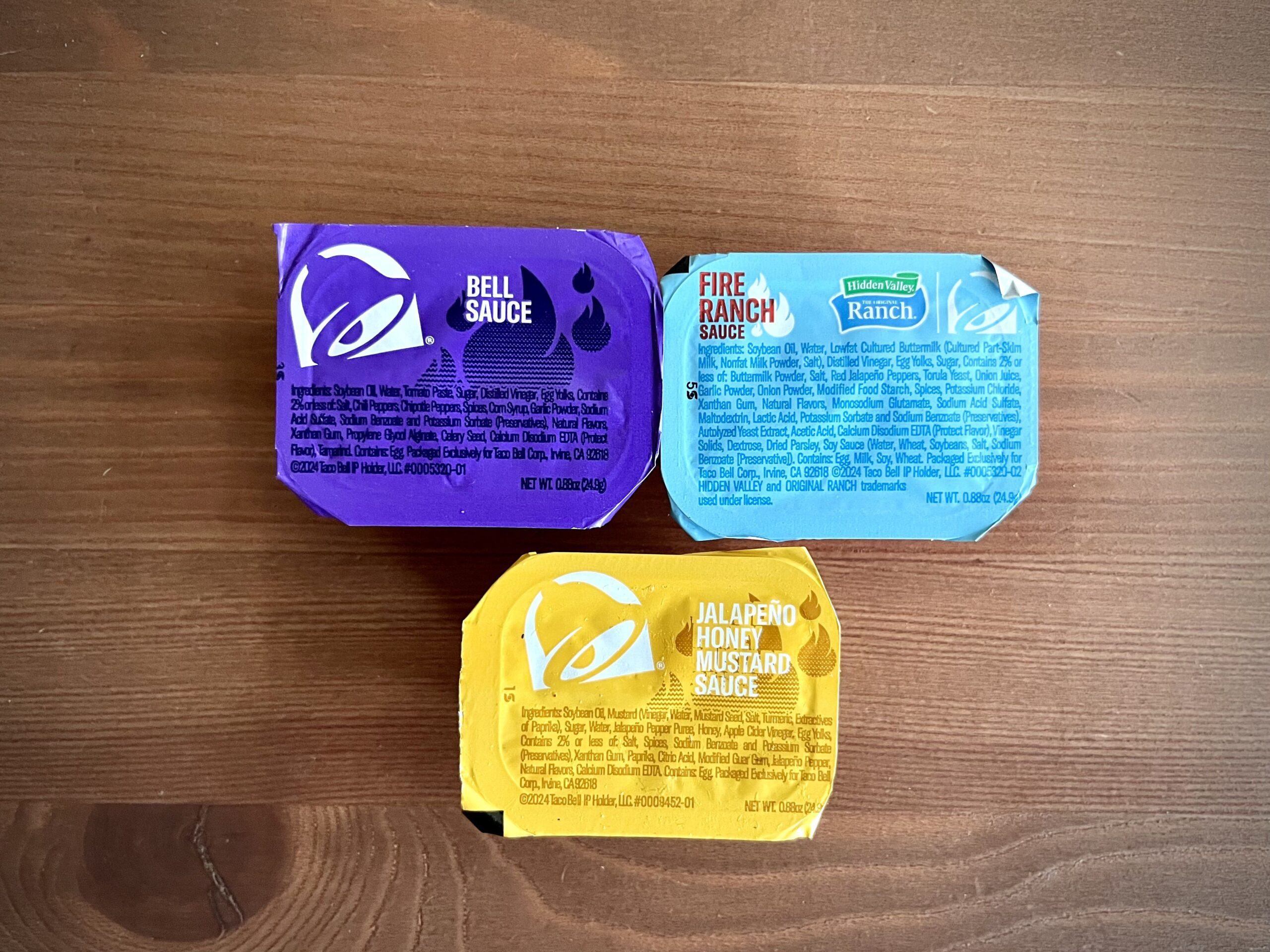 three Taco Bell chicken nugget sauces: fire ranch, jalapeno honey mustard, and bell sauce