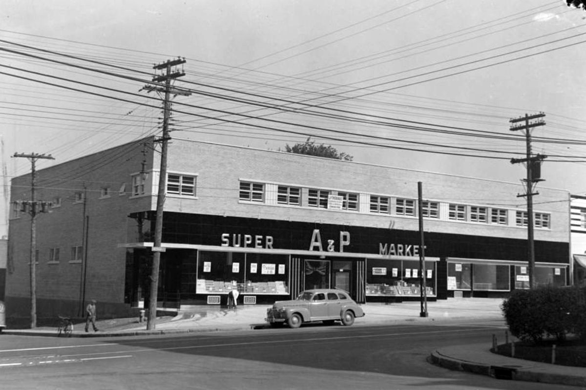 Front exterior of A&P Supermarket, Snowdon, Quebec, 1941, vintage black & white image, a single car is parked along the road outside it, lots of electrical lines