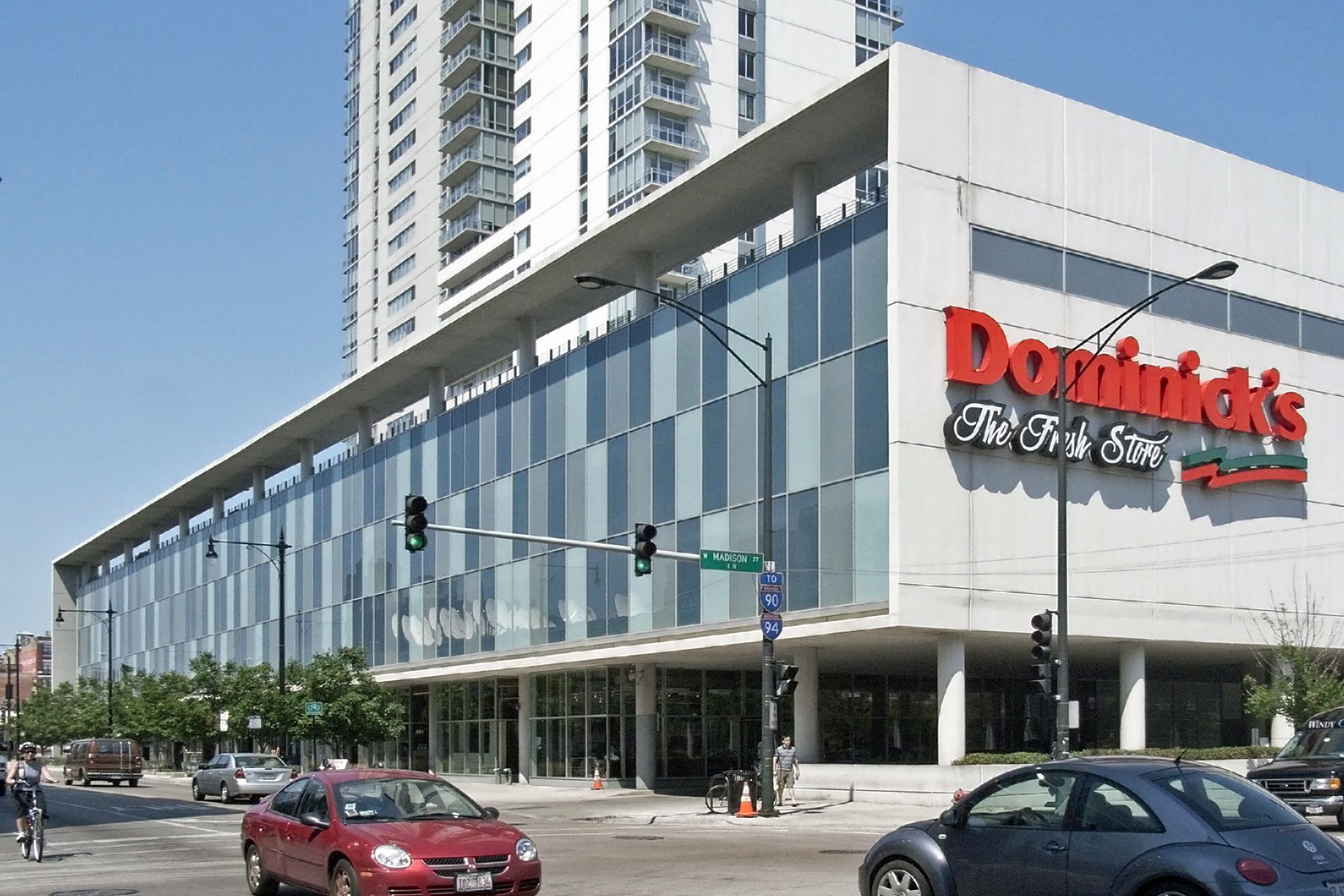 Front and side exterior of Dominick’s Grocery Store, Chicago, 2007, large light beige building with windows on one side, cars on the street in the foreground