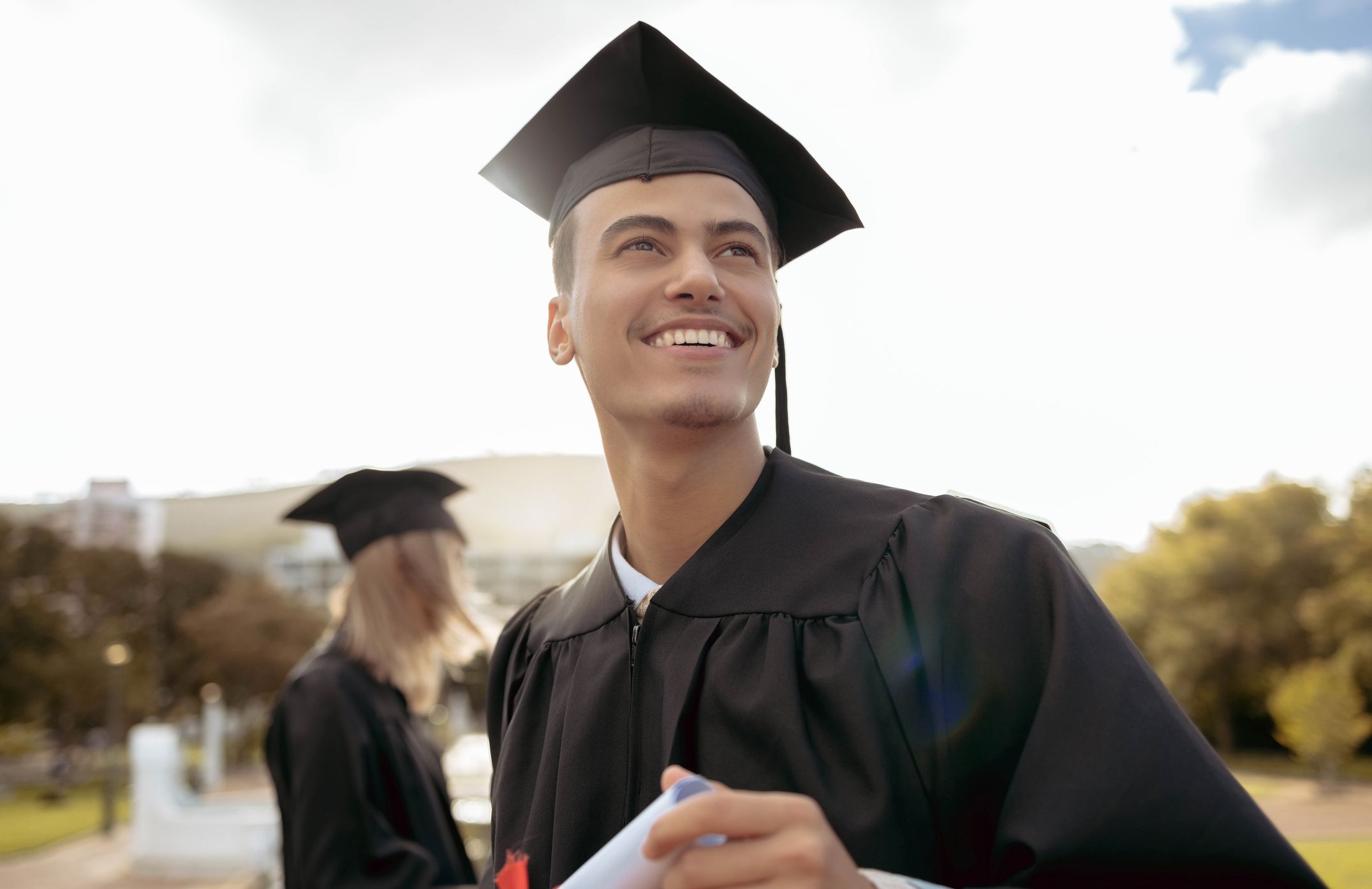 Smiling Male College Student on Graduation Day, Blurred Background