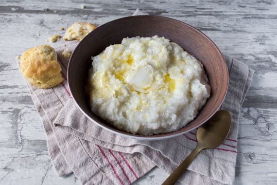 southern grits with biscuits and butter on rustic table top view