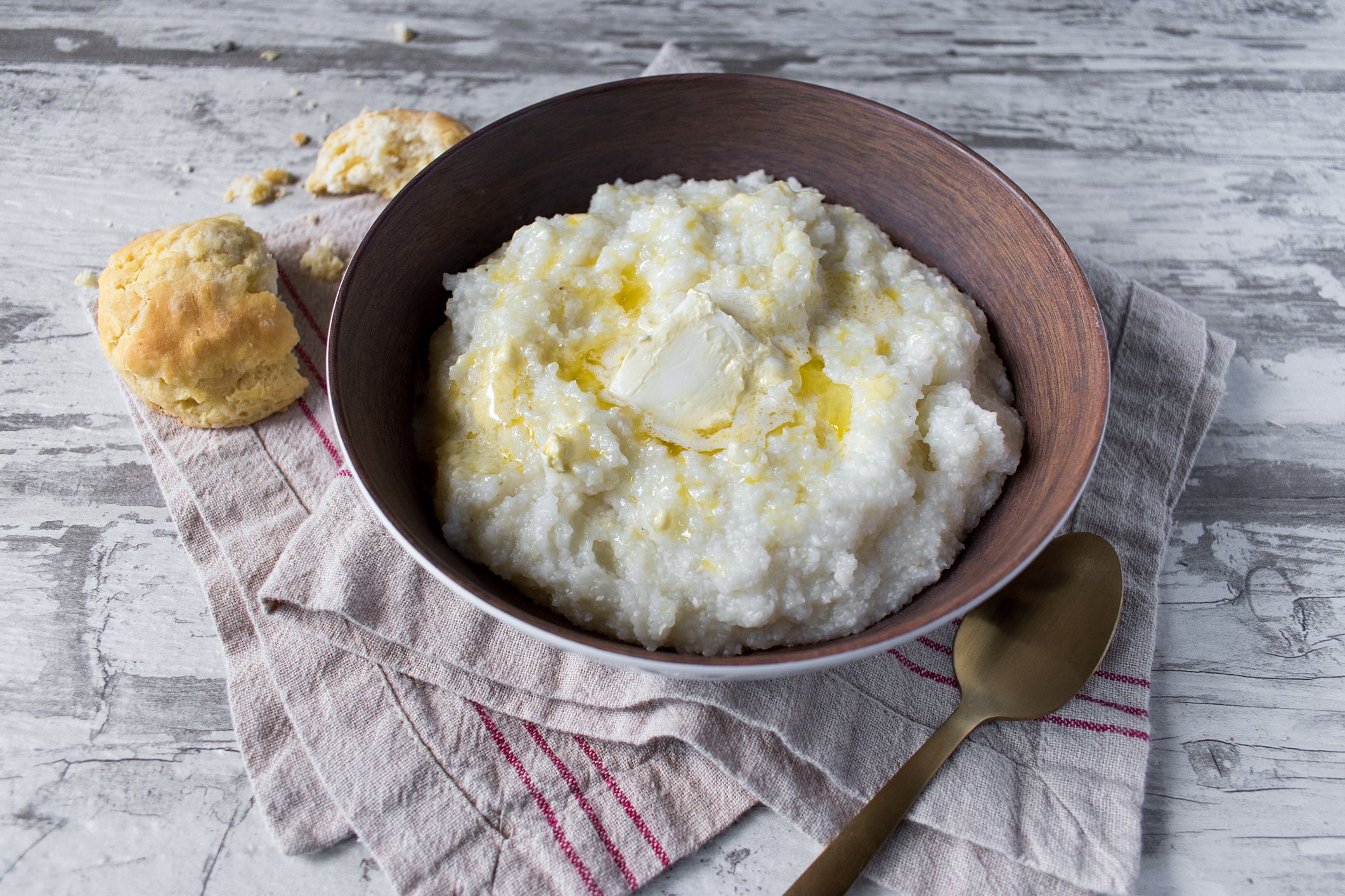 southern grits with biscuits and butter on rustic table top view