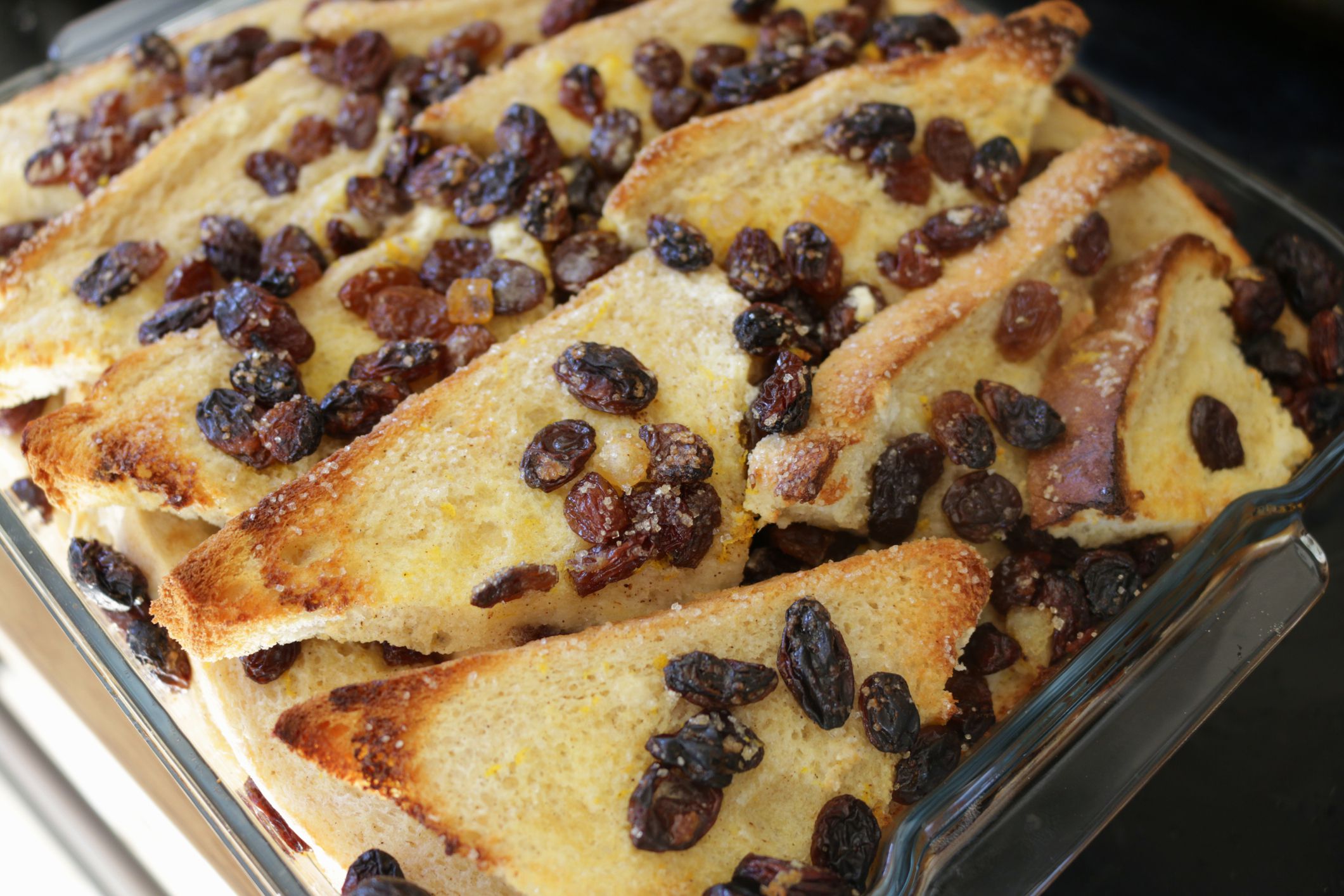 Stock image showing the layered ingredients for a bread and butter pudding in a glass baking dish just out of the oven.