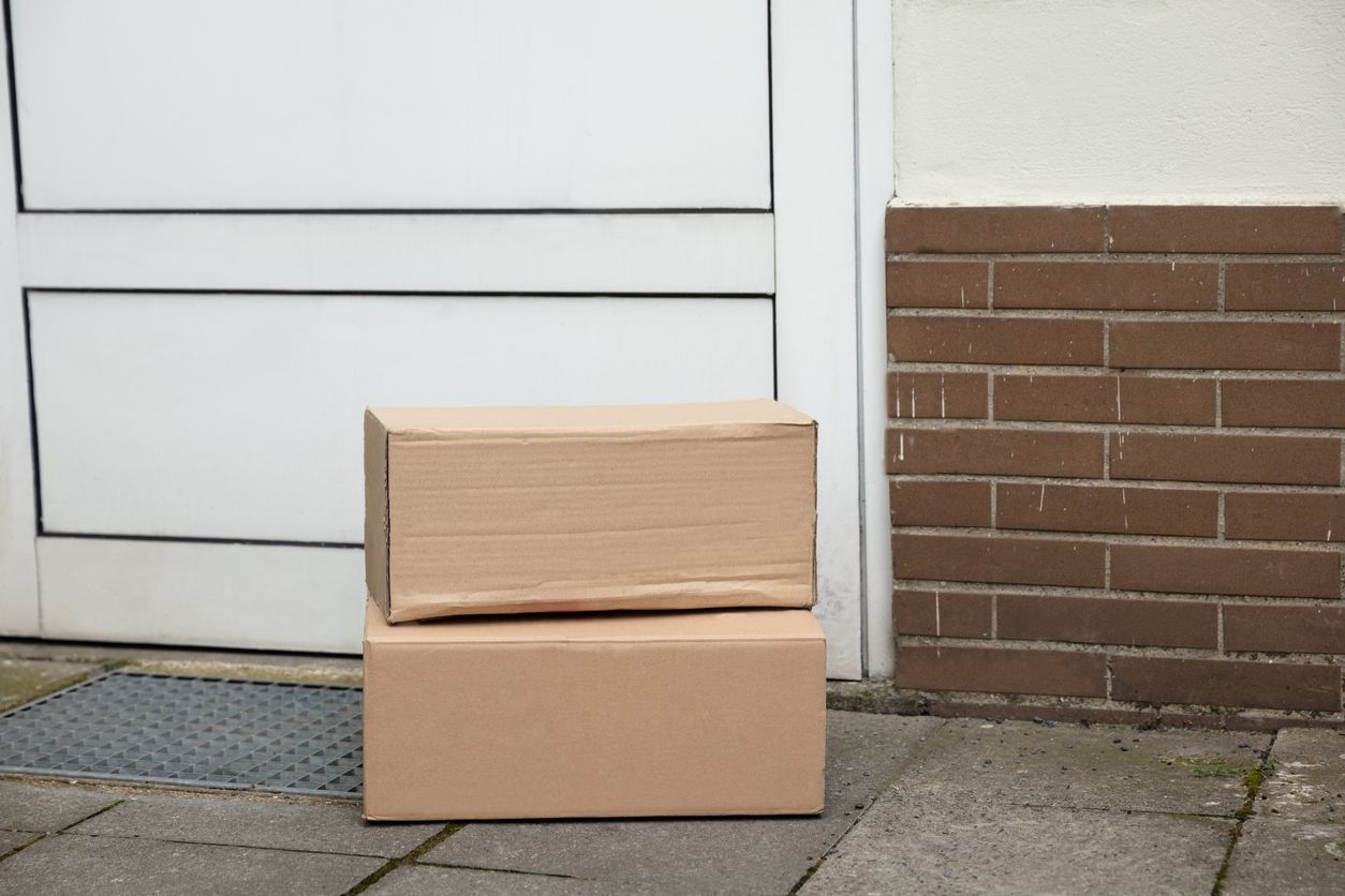 An image of a couple of boxes placed outside of a home.