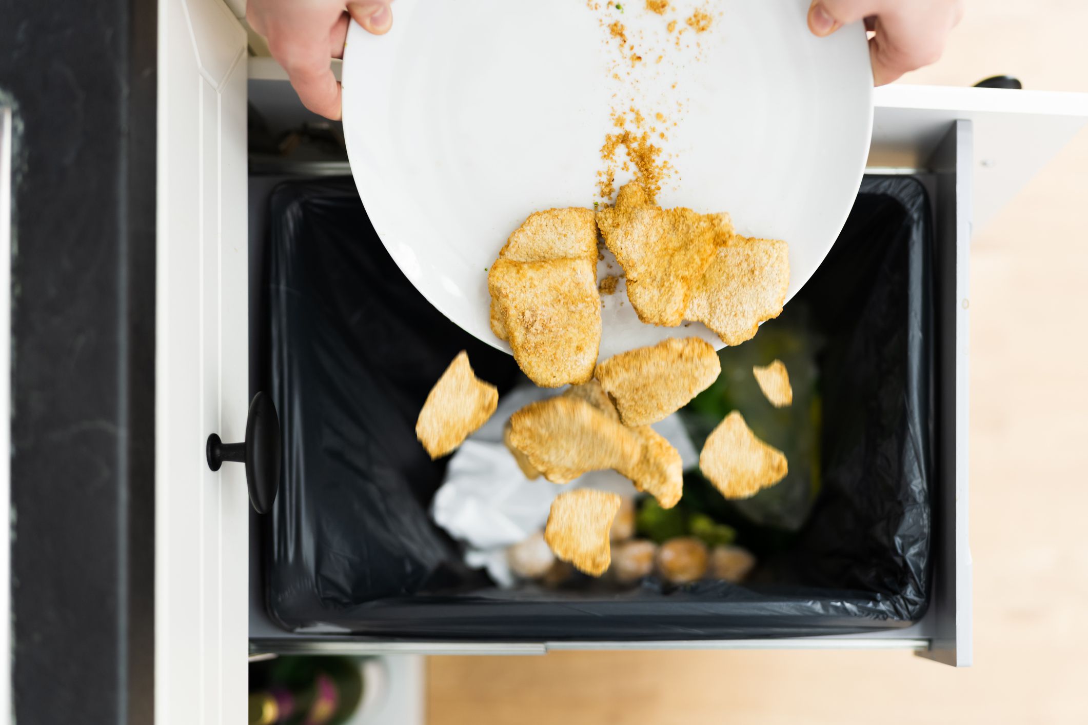 Throwing Away Leftover Food In Trash Or Garbage Dustbin