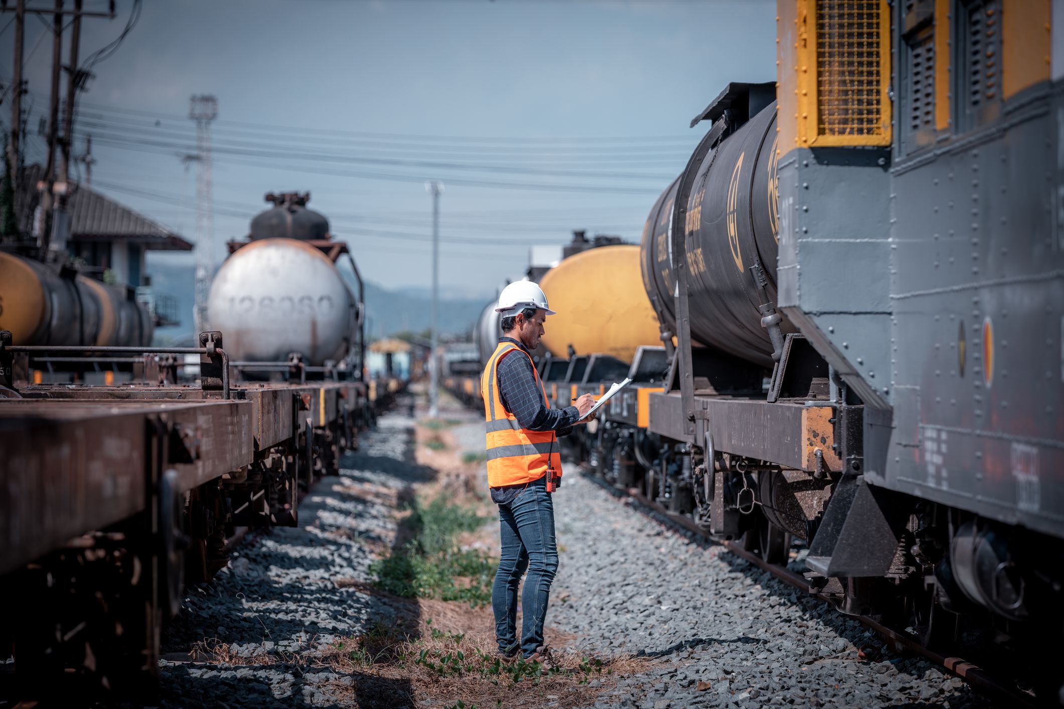Engineer under inspection and checking construction process railway switch and checking work on railroad station .Engineer wearing safety uniform and safety helmet in work.