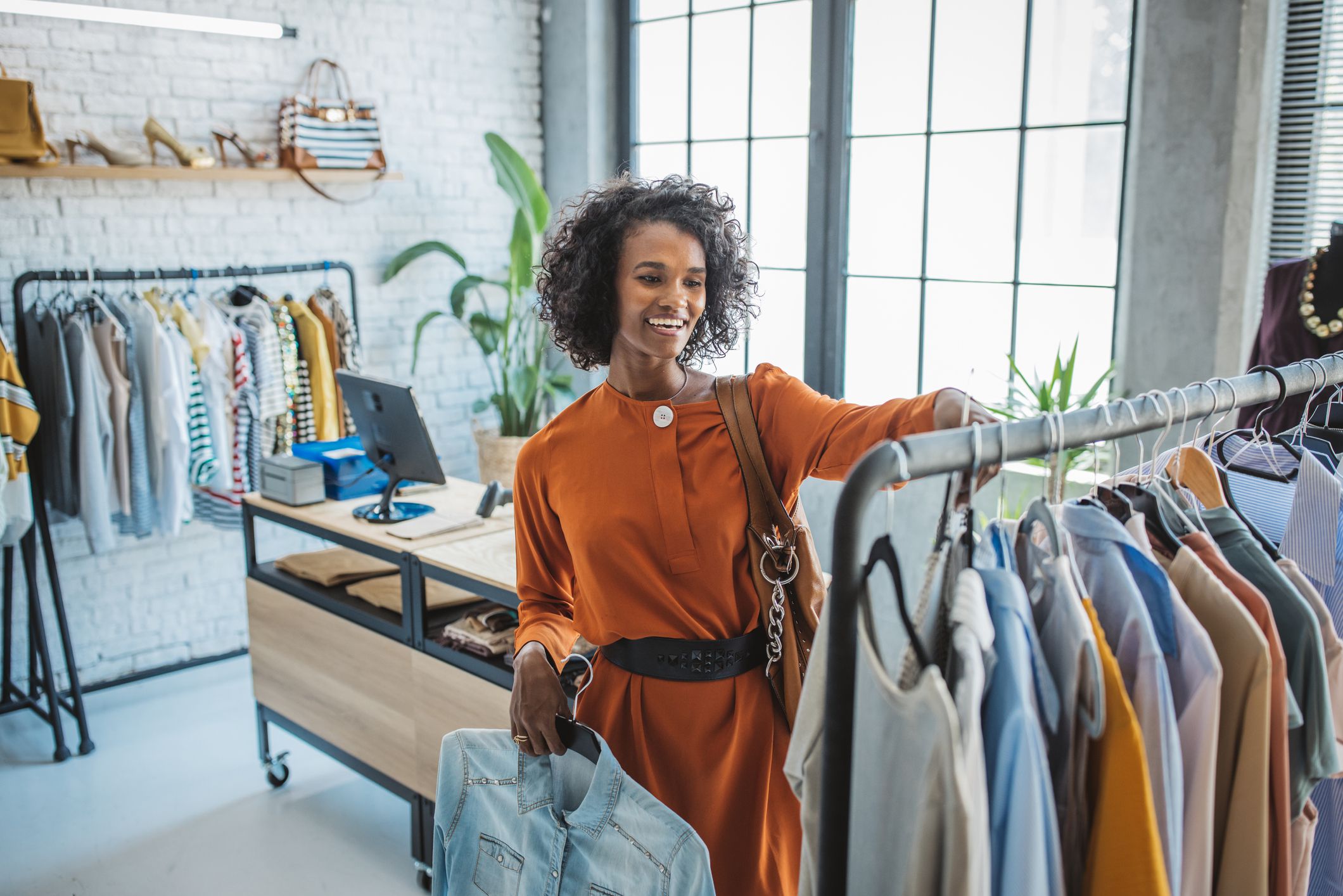 Young woman shopping clothes in thrift store.