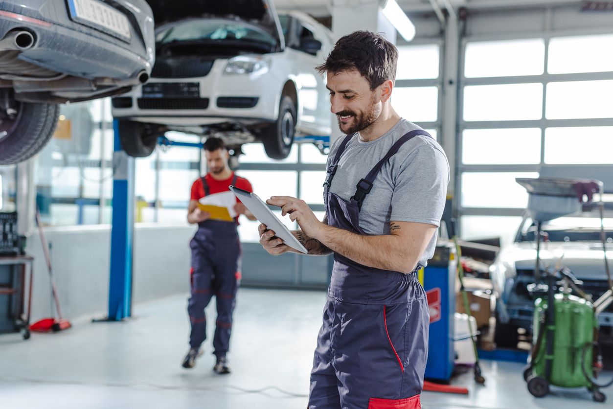 A couple of car repair experts servicing different vehicles.