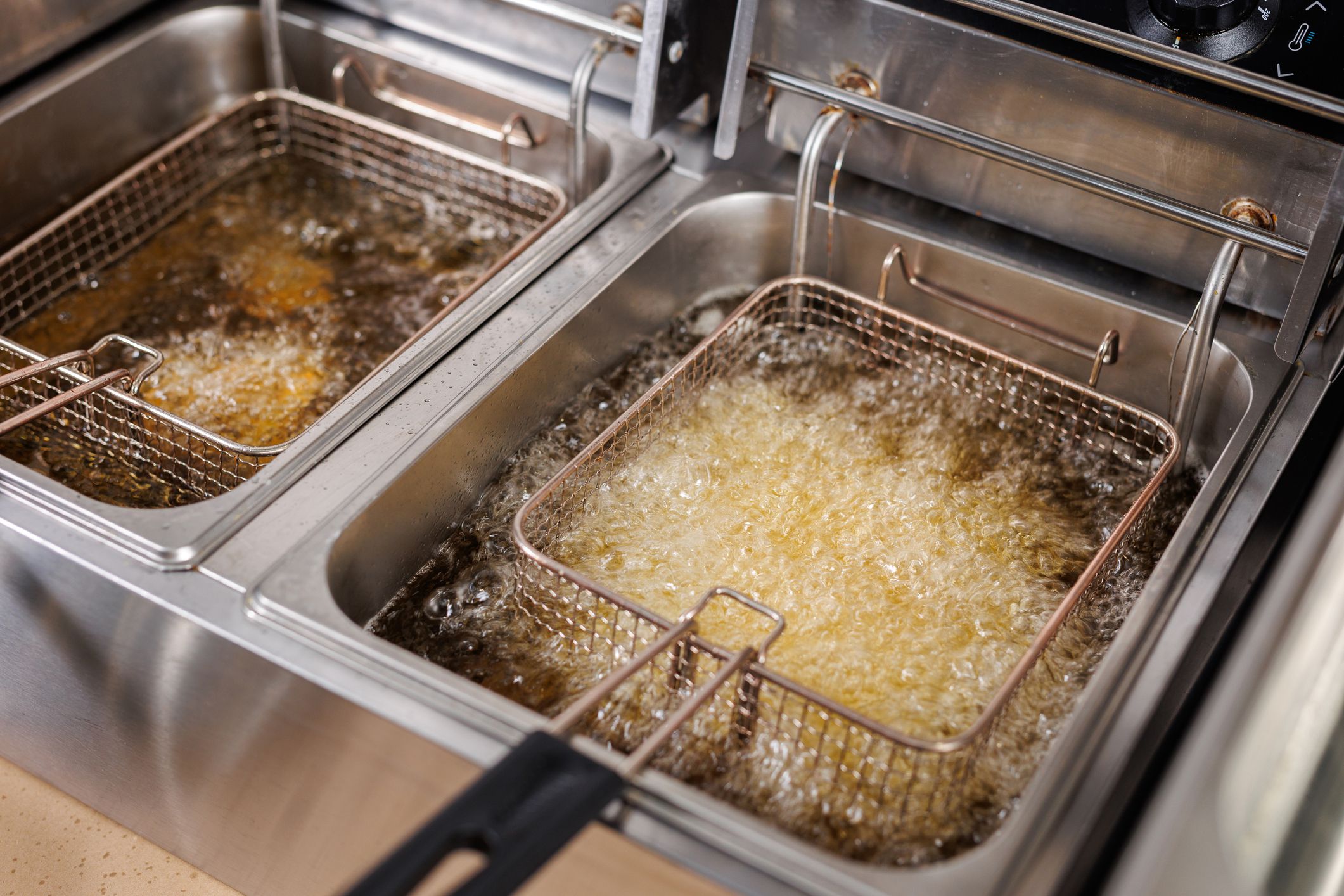 Frying potatoes in fryer for french fries in a restaurant