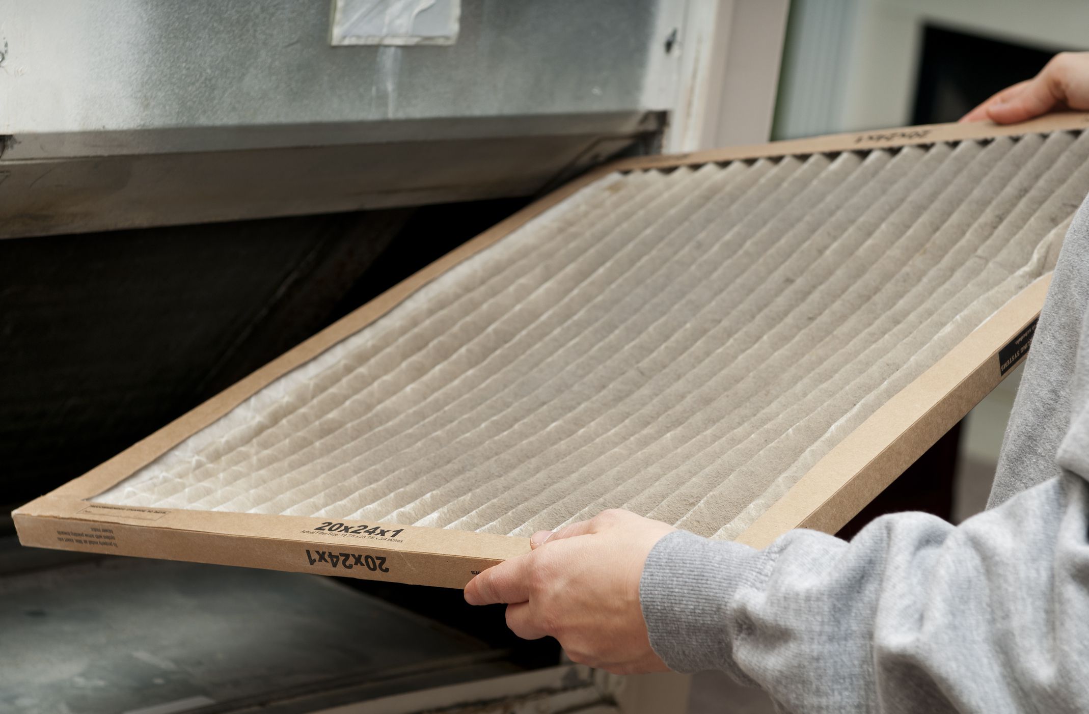 Home owner changing their dirty air filter.