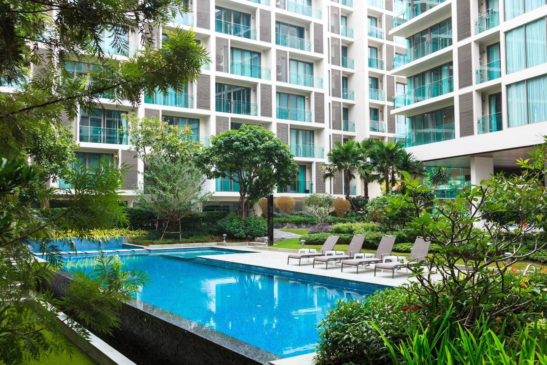 Swimming pool mit apartment houses in the background and garden in Chiang Mai, Thailand