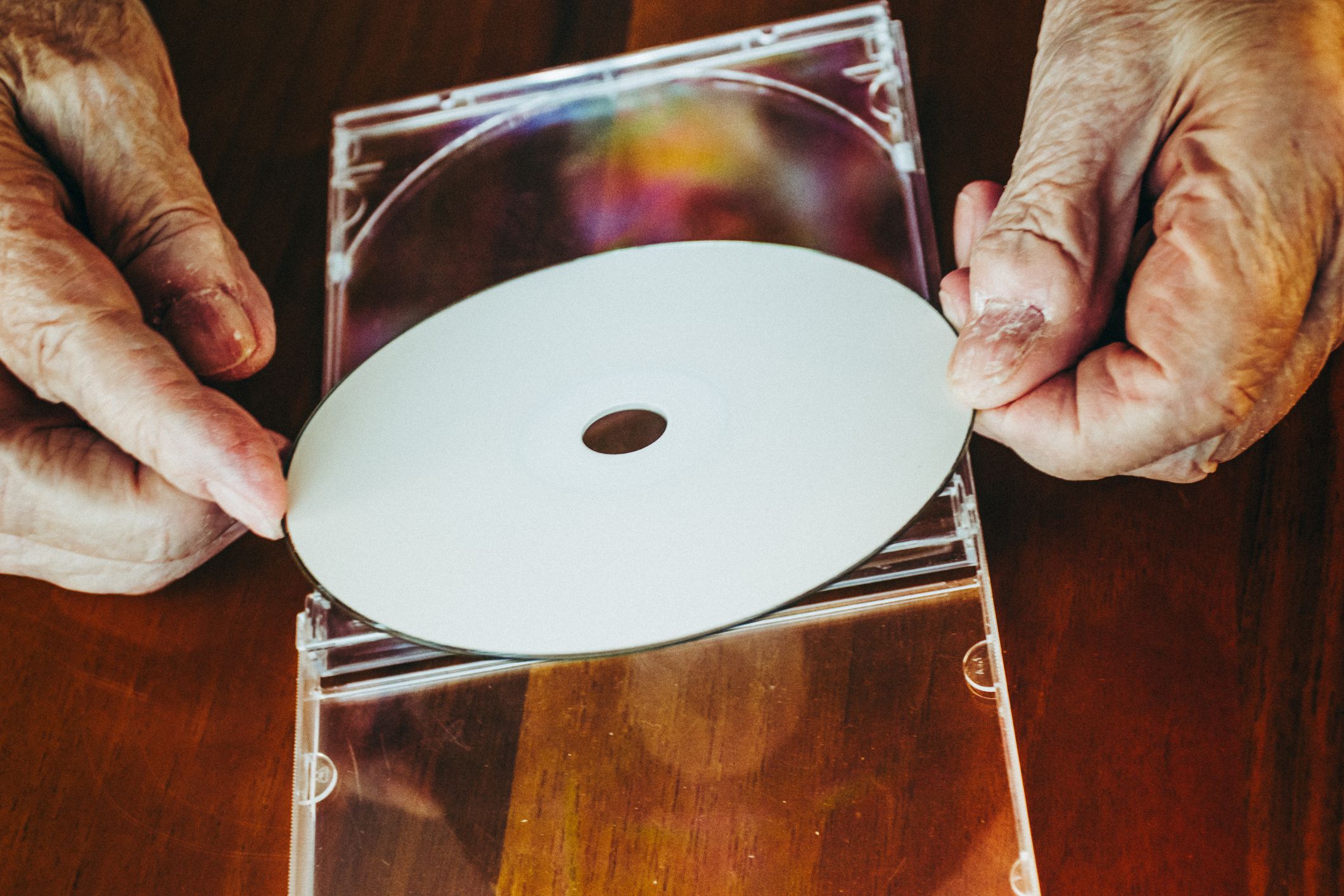 Senior Woman Hands Trying To Open A Compact Disc Case