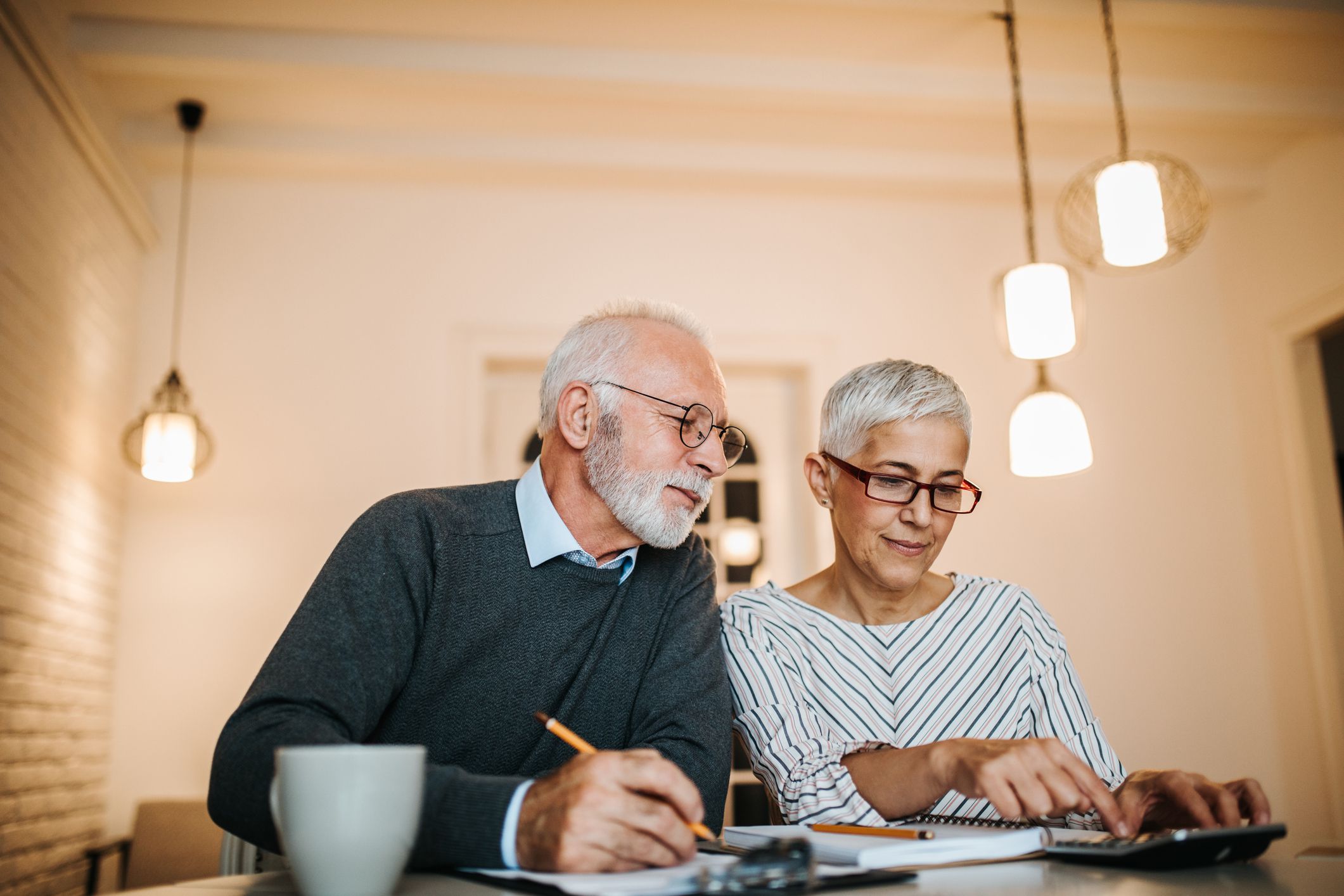Mature couple doing some paperwork and calculations at home
