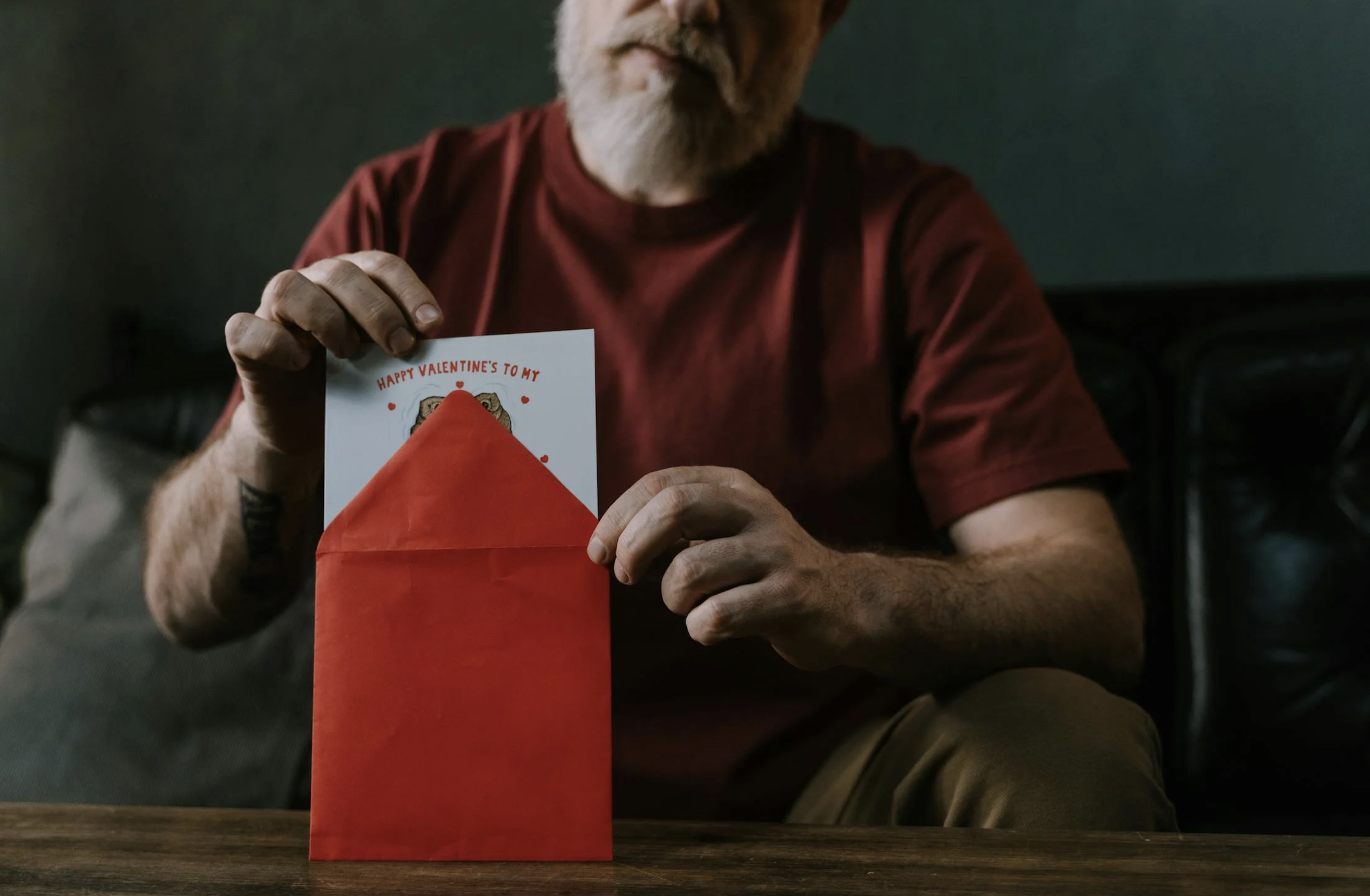 Senior Man Putting a Valentines Letter in a Red Envelope