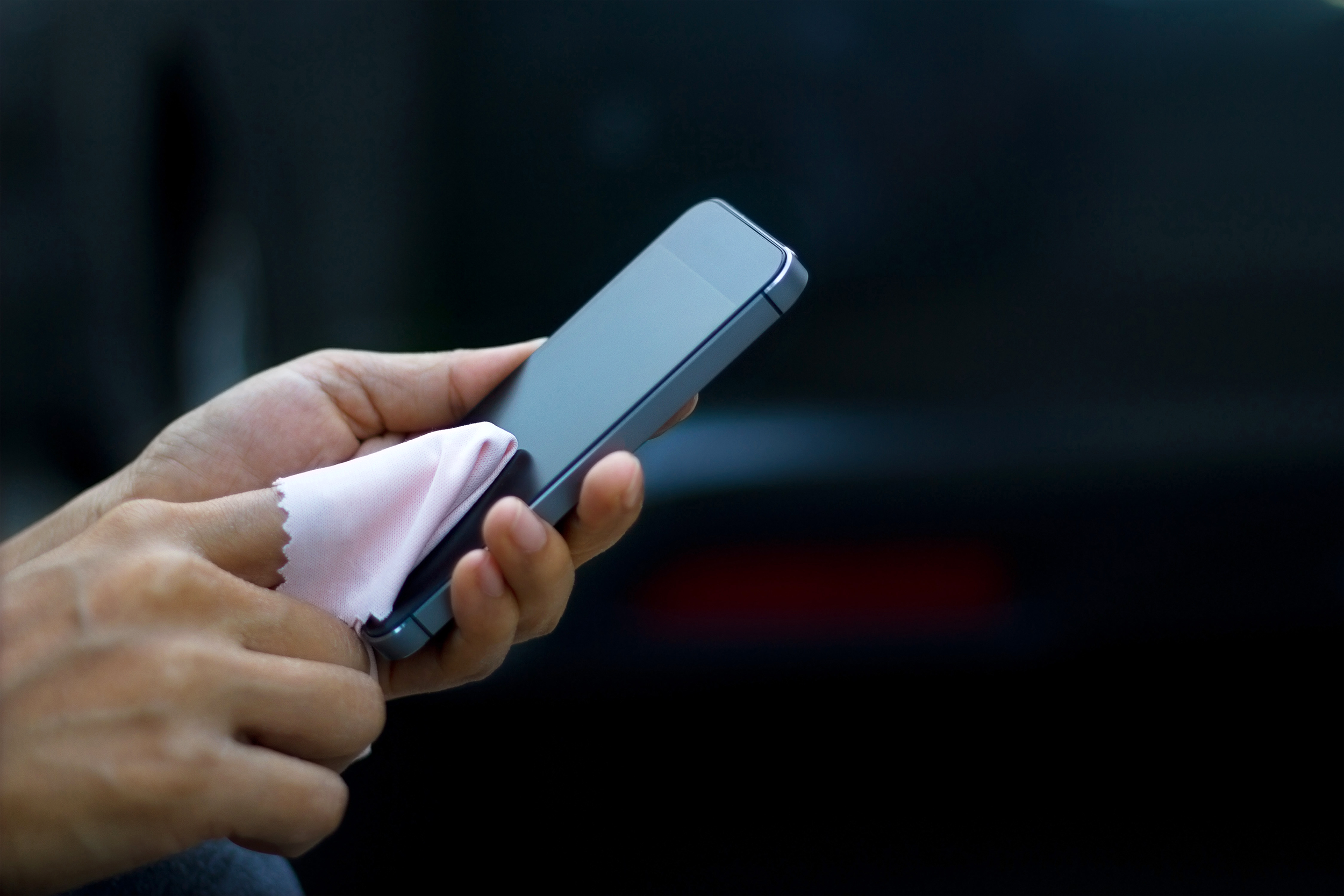 Cleaning a smartphone with a microfiber wipe