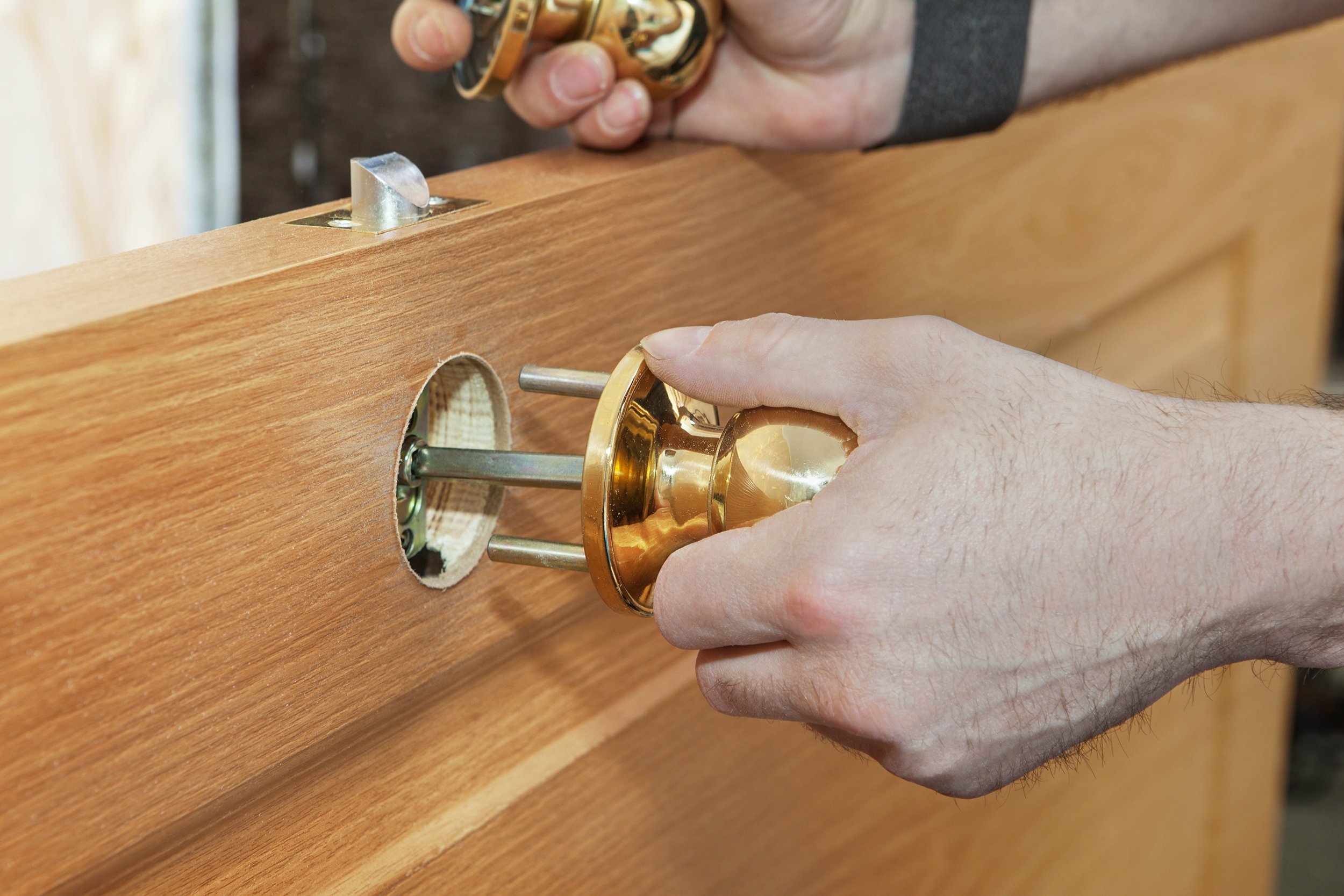 hand holding brass door handle knob for installation