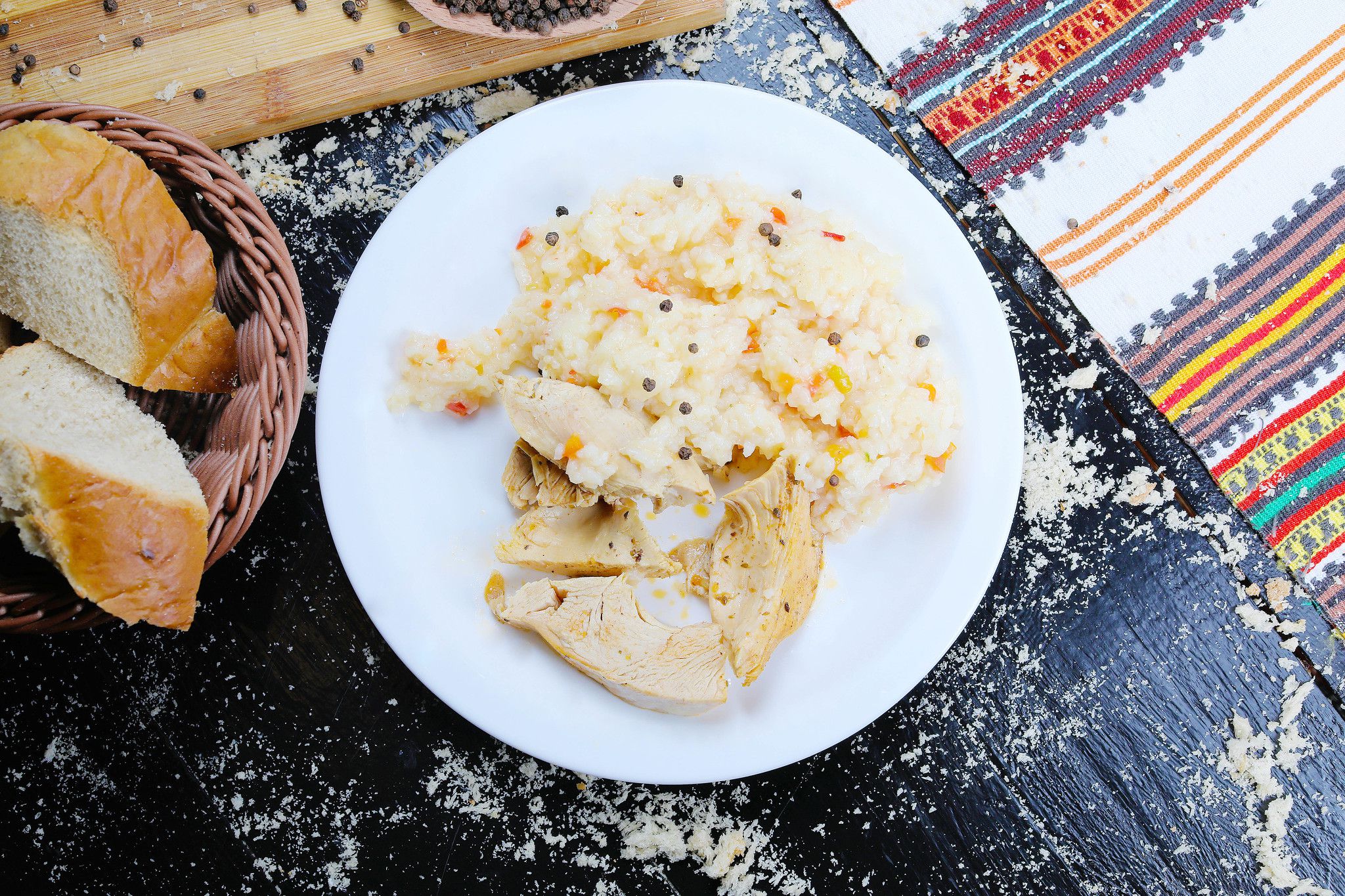 Roast chicken and rice served with homemade bread. Black background